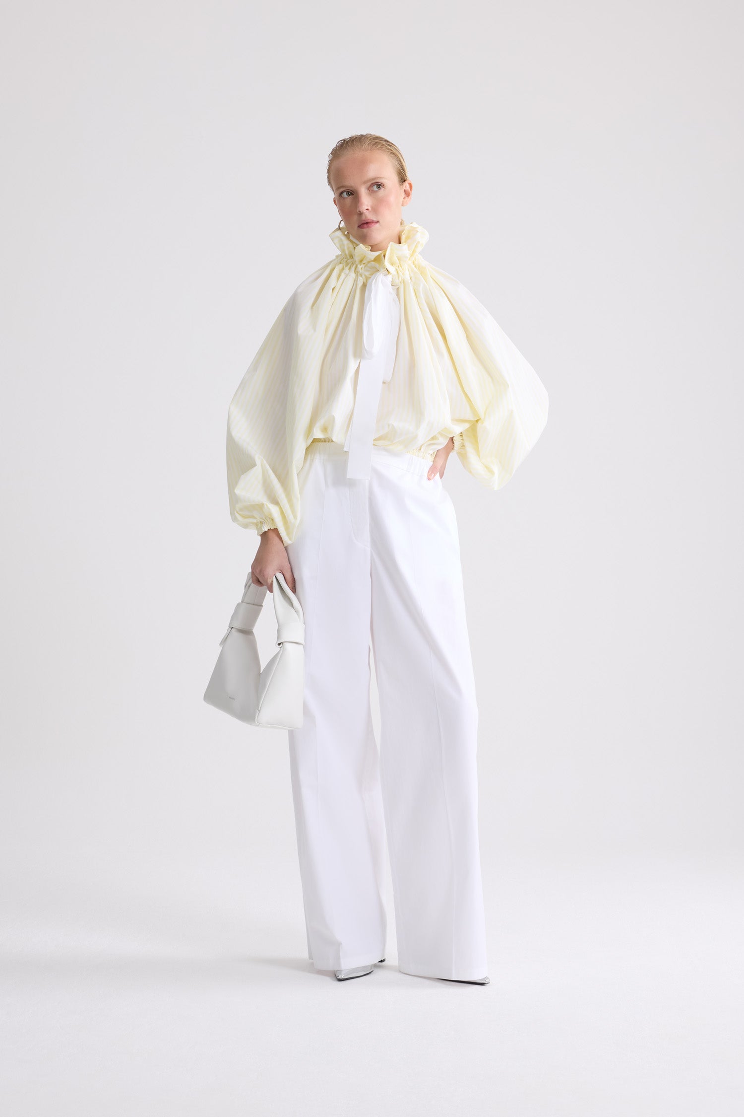 Patou - ストライプ オーガニックコットン アイコニックなボリュームトップス - Lemonade Stripes - イエロー＆ホワイトカラーのストライプ入り オーガニックコットン製 アイコニックなボリュームトップス。際立ったボリューム感のあるシルエット、ネックで結んで、あるいはベアショルダーでまとえます。ギャザー入りフロントにドローストリング付きカラー、グログランのロングタイ。伸縮性のある袖口にバットウィングスリーブ。伸縮性のあるウエスト。
