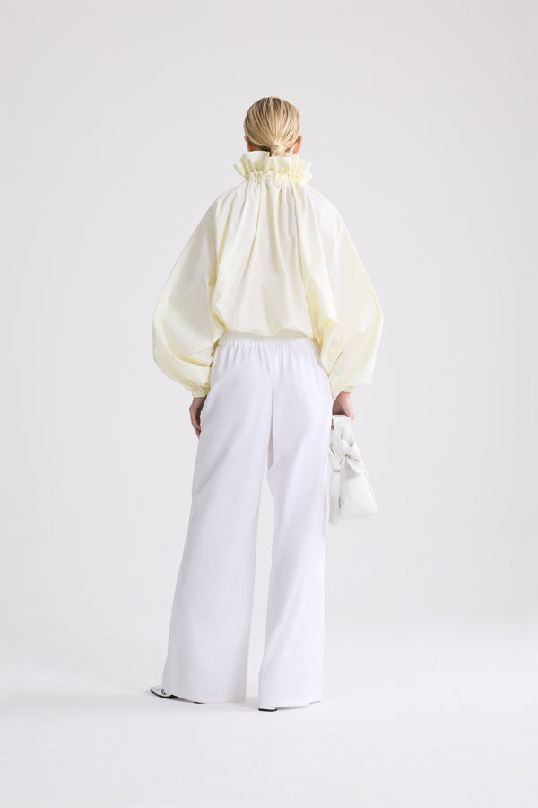 Patou - Top iconico voluminoso a righe in cotone biologico - Lemonade Stripes - Top iconico voluminoso a righe gialle e bianche in cotone biologico. Silhouette molto voluminosa che può être indossata annodata al collo o con le spalle scoperte. Colletto a coulisse con arricciatura frontale e lunghi lacci in gros-grain. Maniche a pipistrello con polsini elasticizzati. Vita elasticizzata.