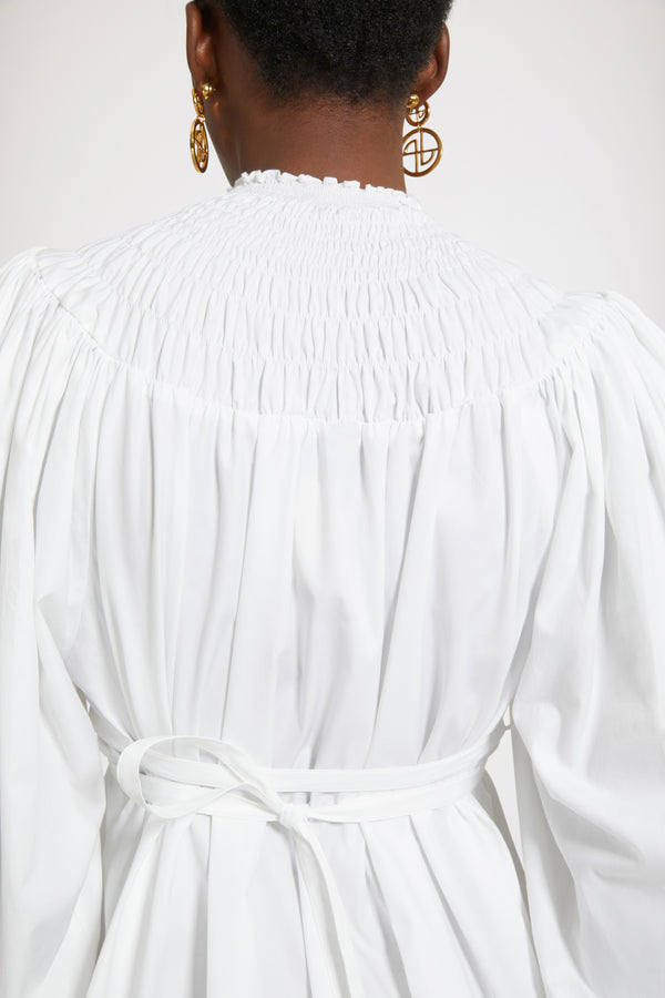 Patou - 오가닉 코튼 스목 칼라 튜닉 - White - 드레스 또는 튜닉? 스타일링 마법을 발휘할 시간입니다.화이트 컬러의 오가닉 코튼 포플린 튜닉. 스목 디테일의 하이 네크라인. 뒷면에 JP 자수 장식. 퍼프 숄더 및 엘라스틱 커프스가 돋보이는 볼륨 슬리브. 앞 또는 뒤로 묶을 수 있는 허리 부분의 탈부착 가능한 벨트. 미니원피스로 착용이 가능합니다.