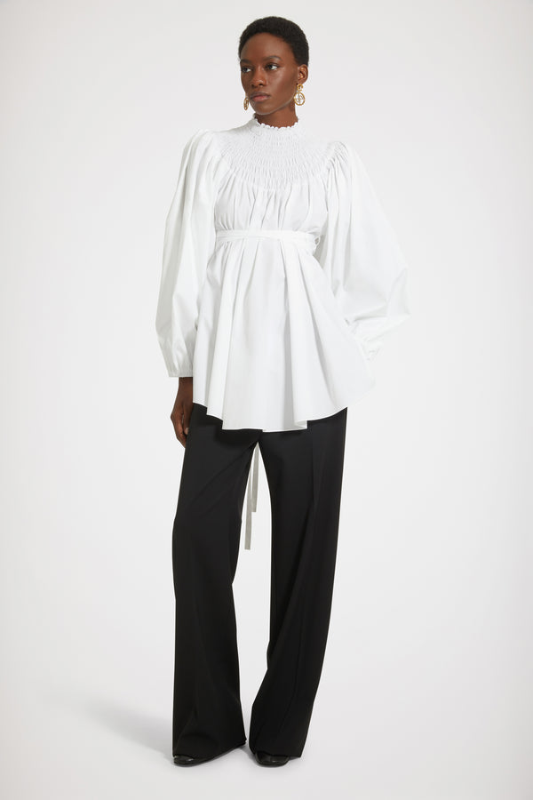 Patou - 오가닉 코튼 스목 칼라 튜닉 - White - 드레스 또는 튜닉? 스타일링 마법을 발휘할 시간입니다.화이트 컬러의 오가닉 코튼 포플린 튜닉. 스목 디테일의 하이 네크라인. 뒷면에 JP 자수 장식. 퍼프 숄더 및 엘라스틱 커프스가 돋보이는 볼륨 슬리브. 앞 또는 뒤로 묶을 수 있는 허리 부분의 탈부착 가능한 벨트. 미니원피스로 착용이 가능합니다.