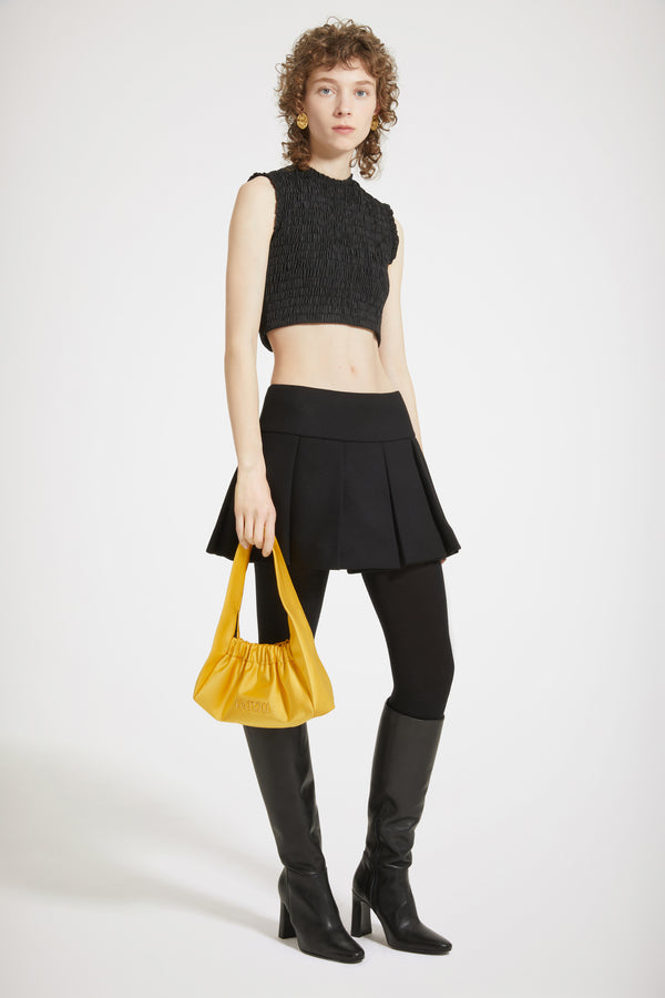 Patou - 친환경 파유 소재의 스목 크롭 탑 - Black - 스목 및 크롭 디자인의 사랑스러운 탑.블랙 컬러 재생 파유 소재의 탑. 피티드 크롭 실루엣. 라운드 넥라인. 슬리브리스 앞면의 JP 자수 장식. 시그니처 JP 풀탭이 달린 뒷면의 골드 톤 양방향 지퍼.밀착되는 핏 스타일.