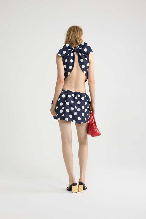 Patou - Top noué en ottoman imprimé recyclé - Navy Polka Dots - Top en ottoman recyclé. Imprimé pois. Coupe courte. Col rond. Dos fendu avec fermeture par nœud. Ourlet à découpe en V.