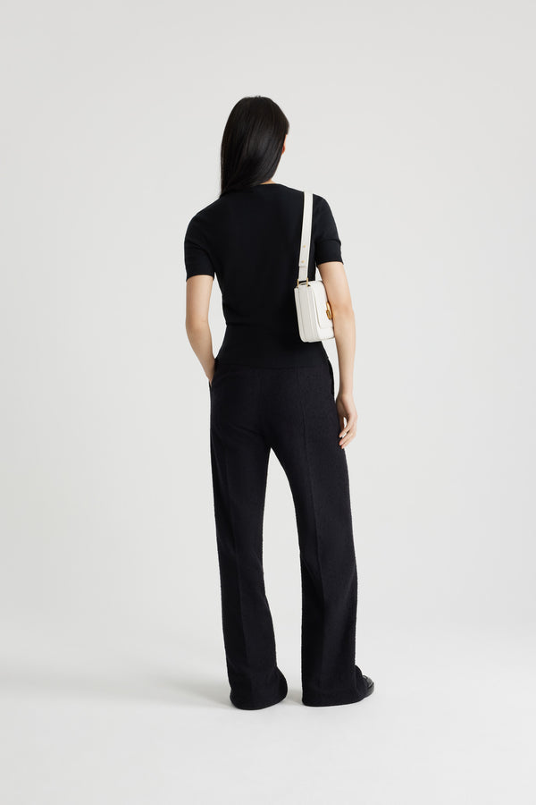 Patou - Pantalone iconico in tweed di lana ecosostenibile e cotone bio - Black - Pantalone in tweed di lana ecosostenibile e cotone bio nero. Modello iconico. Gamba dritta. Chiusura con bottone oro inciso JP e zip sul davanti. Passanti per cinture e tasche laterali. Pinces signature sul retro.