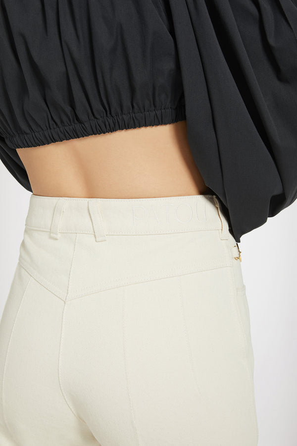 Patou - 재생 코튼 데님 플레어 트라우저 - Natural - 파투에서 선보이는 데님 팬츠.내추럴 에크루 컬러의 재생 코튼 데님 소재. 플레어 레그. 미드 라이즈. 앞면의 골드 톤 Patou 인그레이빙 버튼. 벨트 루프. 웨이스트밴드의 Patou 로고 자수 장식. 앞면과 뒷면의 다트선, 중앙 주름선. 앞면 포켓 2개, Patou 인그레이빙 골드 톤 장식. 뒷면의 시그니처 곡선 솔기.허리 부분이 꼭 맞는 피티드 스타일입니다.