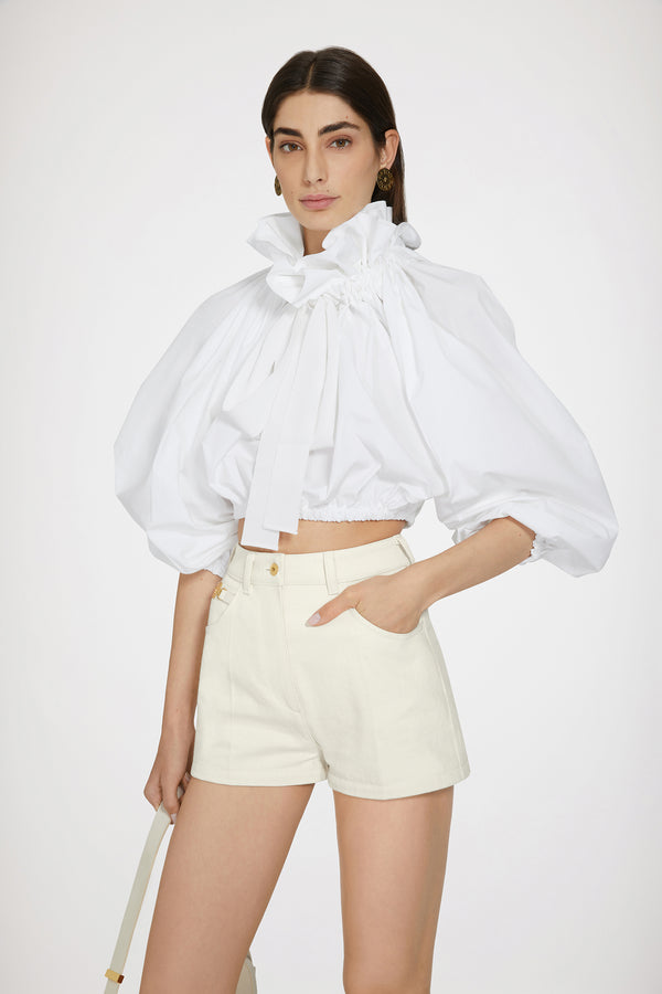 Patou - 再生コットンデニム ミニショートパンツ - Natural - ミニなのに存在感たっぷり。エクリュの再生コットン デニムショートパンツ。ハイウエスト。ミニ丈。フロントにゴールドトーンのパトゥ刻印入りメダリオン装飾。フロントにゴールドトーンのパトゥ刻印入りボタン。ベルトループ付き。サイドにポケット。ウエストにパトゥの刺繍。バックにVシーム。