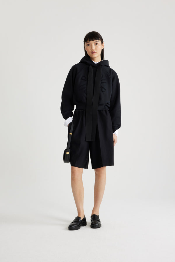 Patou - Bermuda in misto lana riciclata - Black - Bermuda in misto lana riciclata nero. Lunghezza al ginocchio. Vita elasticizzata in faglia. Tasche ai lati. Pieghe sul davanti.