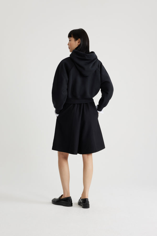 Patou - Bermuda in misto lana riciclata - Black - Bermuda in misto lana riciclata nero. Lunghezza al ginocchio. Vita elasticizzata in faglia. Tasche ai lati. Pieghe sul davanti.