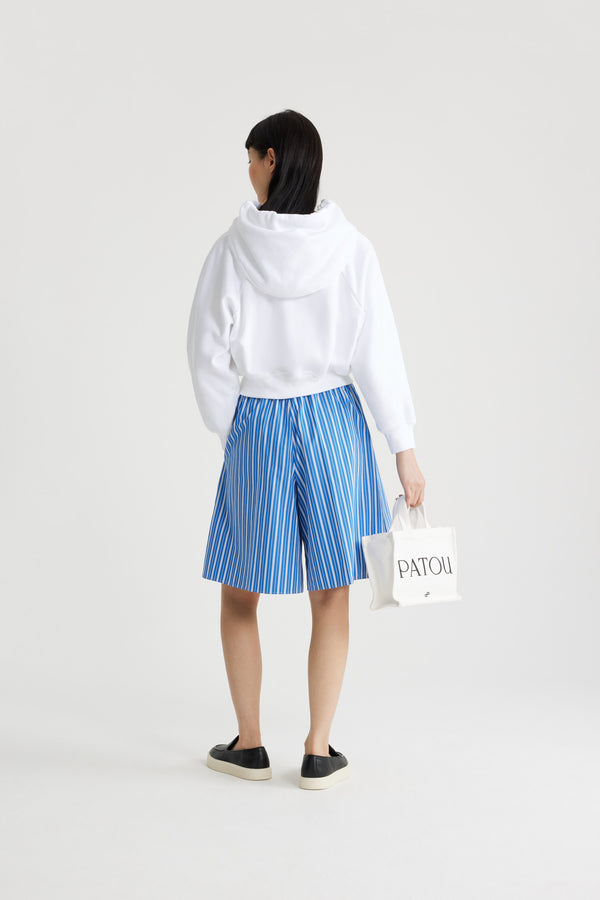Patou - Lang geschnittene Shorts aus bedruckter, nachhaltiger Baumwolle - Victoria Blue Stripes - Shorts in Victoria Blue aus nachhaltiger Baumwolle. Gestreiftes Muster. Knielang. Elastischer Taillenbund. Kontrastierender Bund. Zwei Seitentaschen.