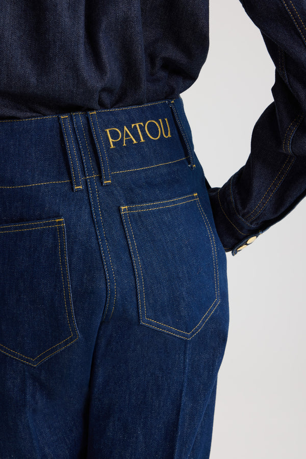 Patou - Wide waistband trousers in cotton denim - Rodeo Blue - Rodeo Blue cotton denim trousers. Mid to low waist. Straight leg. Belt loops. Fastens via a gold-tone Patou logo-engraved button and concealed zip at the front. Pockets at the sides. Pressed crease at the front.
