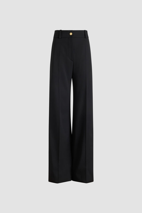 Patou - Flared tailored trousers in sustainable technical wool - Black - Black sustainable technical wool twill trousers. Long flared leg. Gold-tone JP monogram-engraved button and concealed zip at the front. Belt loops. Pockets at the sides. Stitched crease at the front and back.