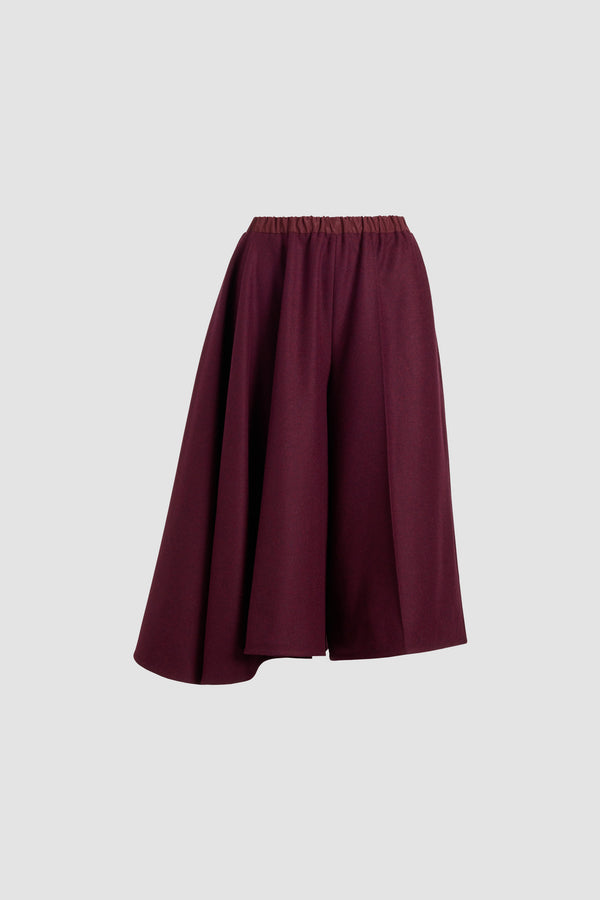 Patou - Asymmetric bermuda shorts in recycled wool blend flannel - Syrah - Syrah burgundy recycled wool blend flannel shorts. Knee length. Mid waist. Asymmetric silhouette with pleating on one side. Elasticated waist. Pressed crease at the front and back.