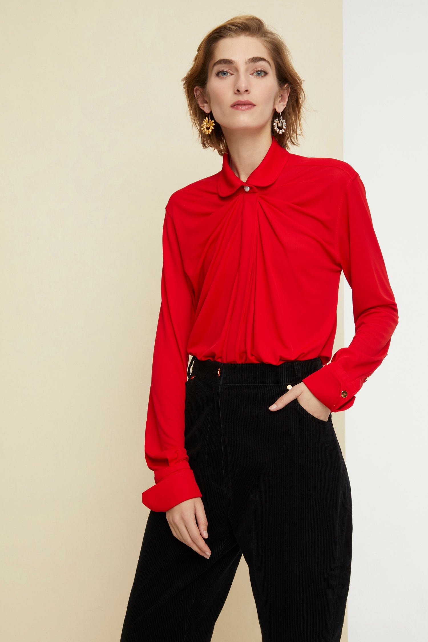 Patou - Blouse en jersey à col claudine - Poppy - Le col s’arrondit et s’affirme.Blouse longue en jersey rouge coquelicot. Un classique du répertoire Patou revisité avec un col claudine. Silhouette drapée. Bouton en nacre au col, gorge cachée et boutons aux poignets.