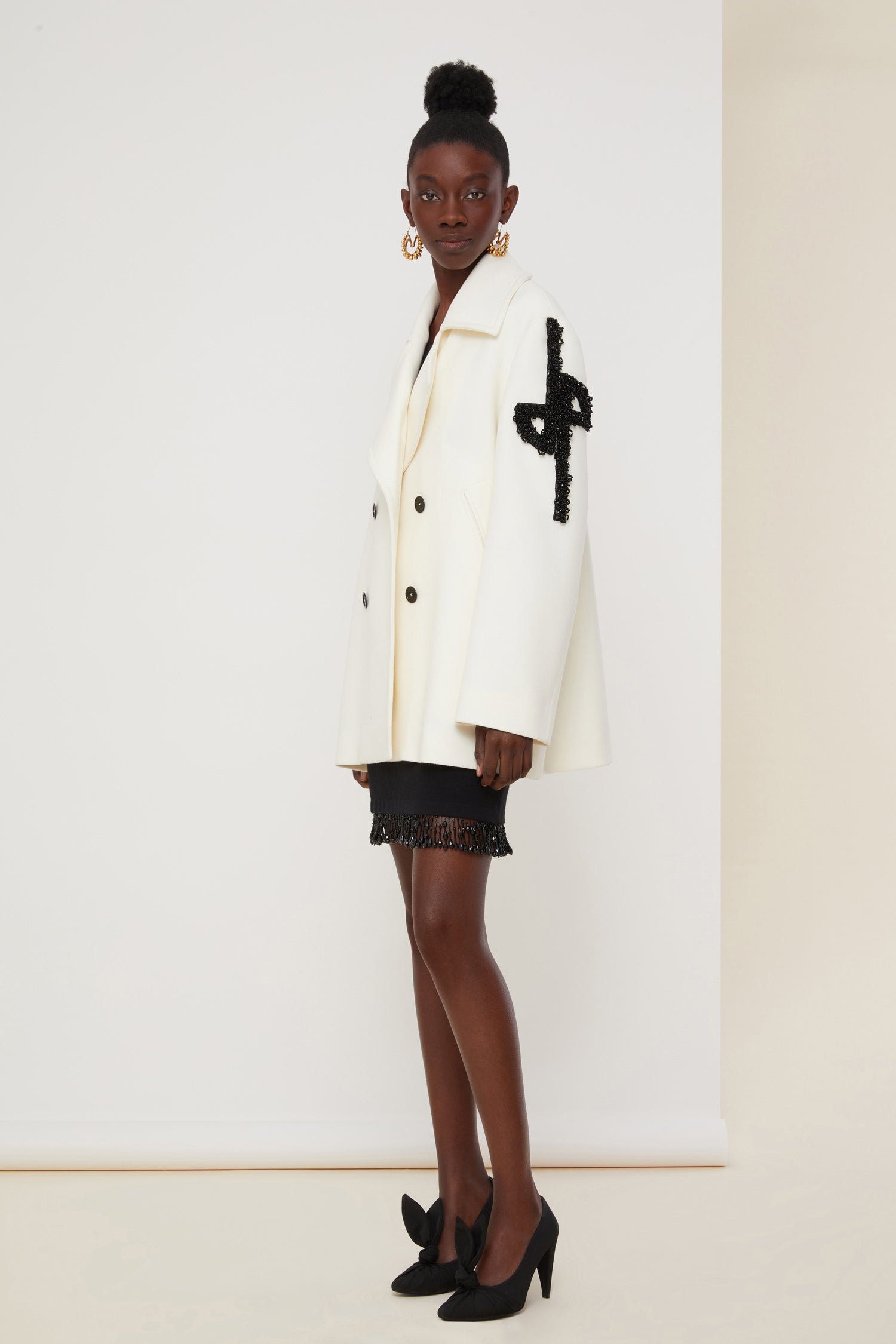 Patou - Jewelled logo peacoat - Pearl - The logo, a signature and an embellishment.Pearl white virgin wool peacoat. Double-breasted style with exaggerated lapels. JP logo in black pearls on the left sleeve. Contrasting black buttons. Welt pockets. Fully lined.