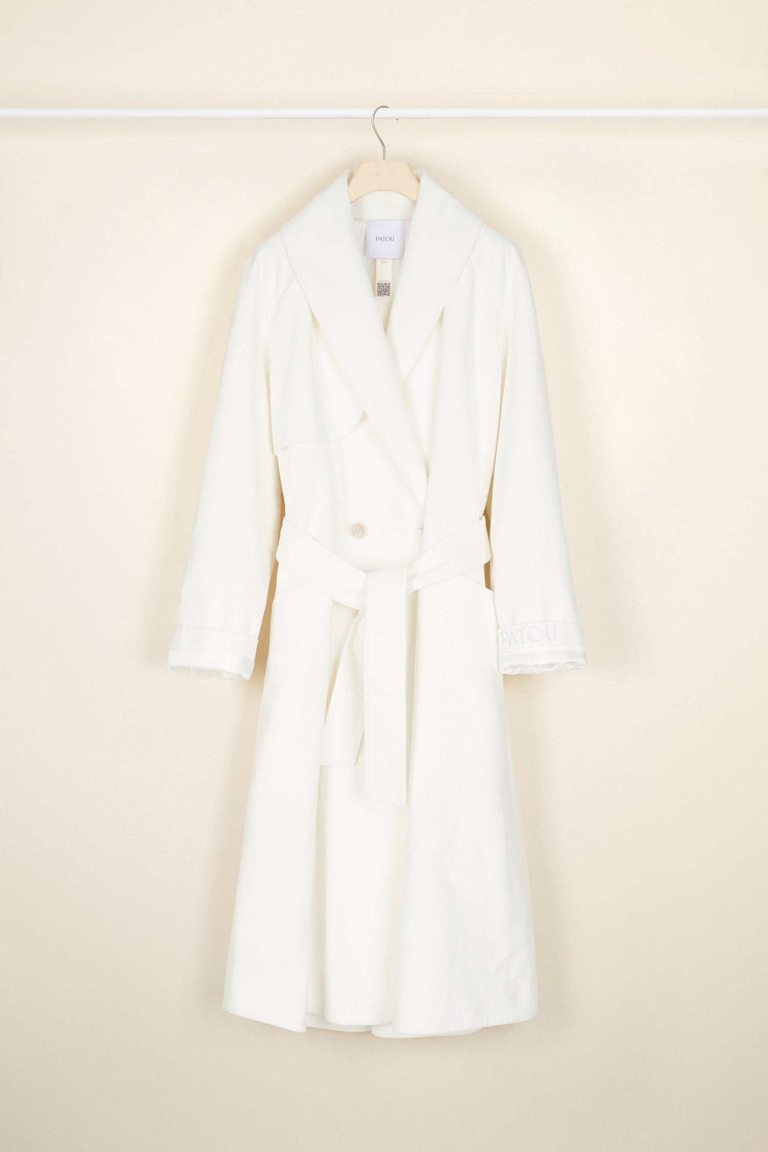 Patou - Corduroy trenchcoat - Pearl - A tailoring classic with a soft velvet touch.Signature Patou trenchcoat in pearl white corduroy. Double-breasted style with a slight A-line silhouette. Button fastening and belted waist. Two pockets at the sides. Fully lined.