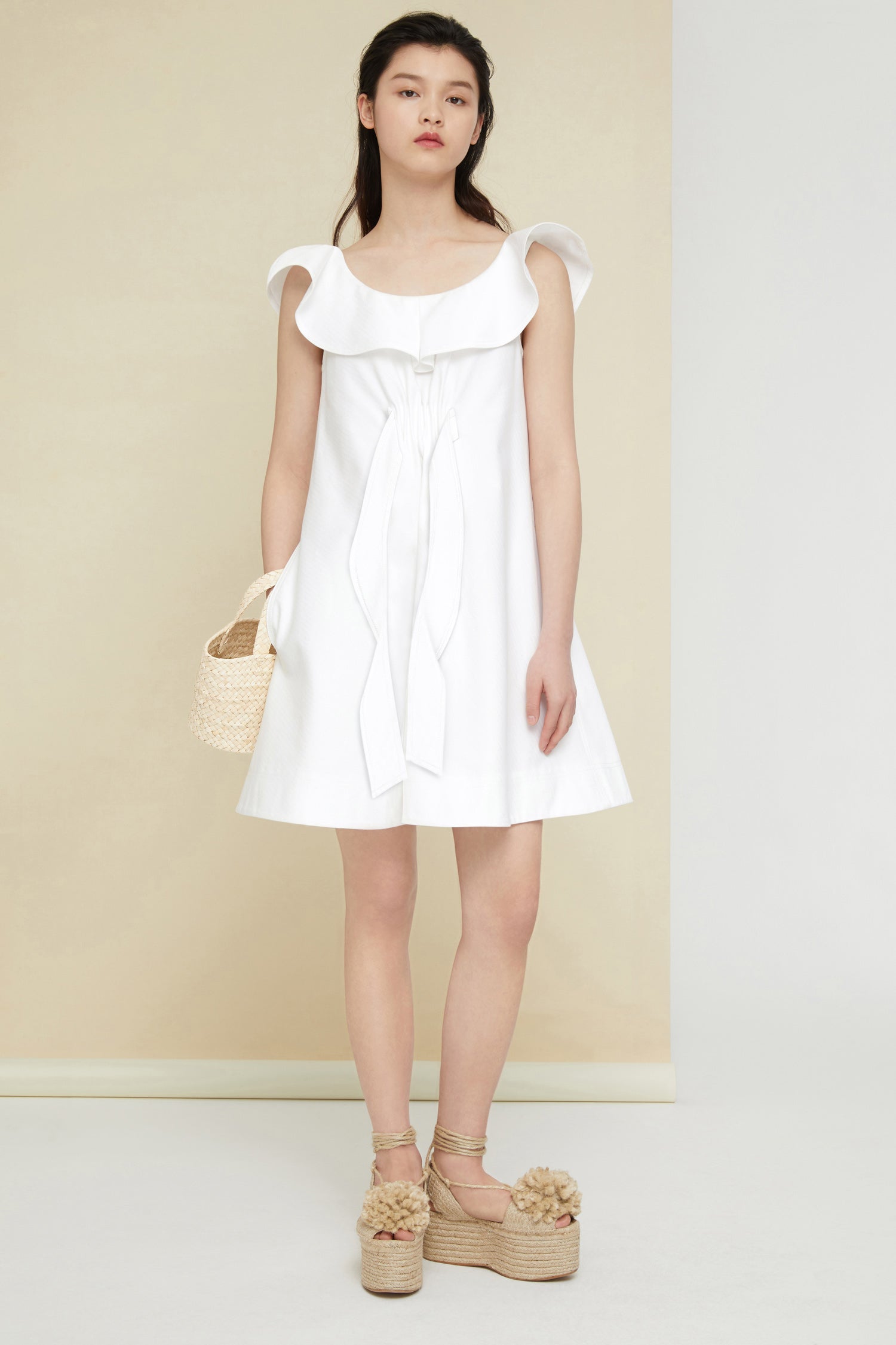 Patou - Robe à volants en coton chevronné - Pearl - Les volants donne de la légèreté au coton.Robe courte en coton blanc perle à motifs chevrons. Surpiqûres ton-sur-ton. Silhouette légèrement évasée. Modèle sans manches avec encolure volantée. Détail froncé et pans de tissus à l’avant. Poches latérales. Glissière cachée sur le côté.