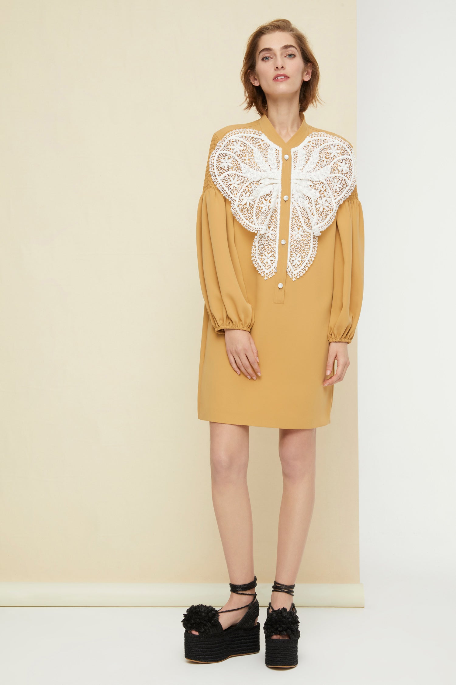 Patou - Lace bib dress - Sand - The day dress is best worn with a touch of lace.Sand-coloured cady dress with white lace bib. Mother-of-pearl buttons down the front. Long sleeves, smocked at the top with elasticated cuffs. Pockets at the sides.