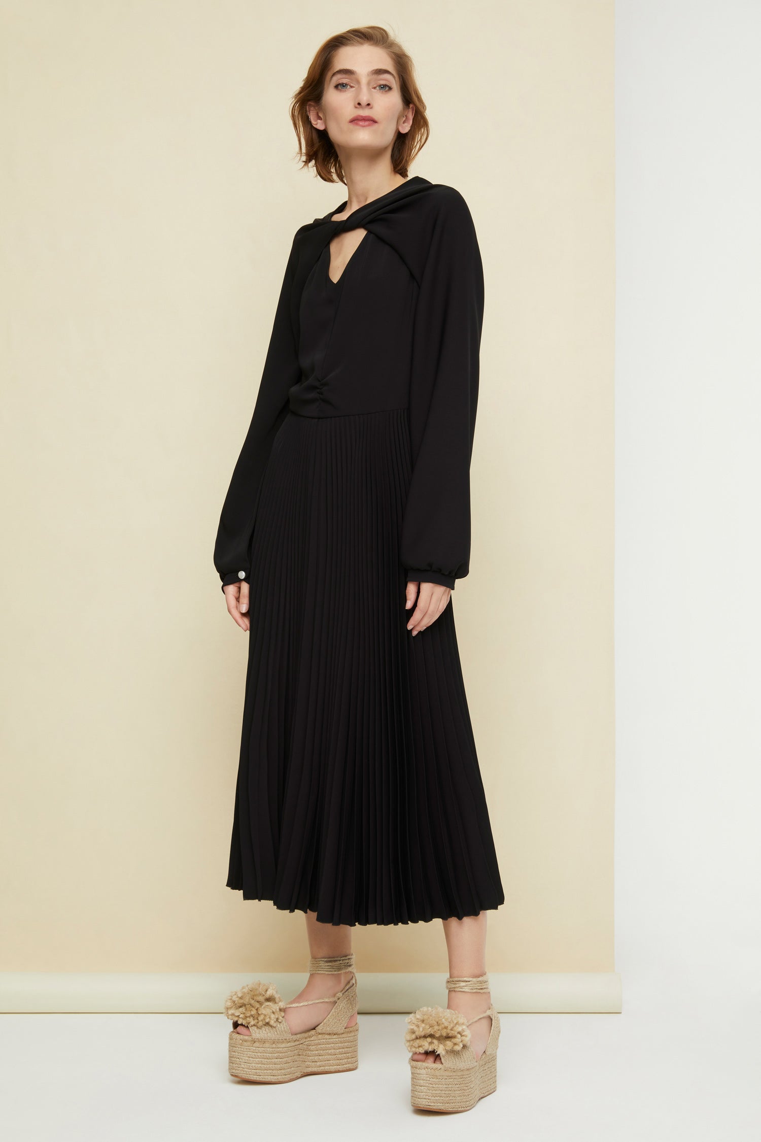 Patou - Twisted neckline pleated midi dress - Black - Twisting and pleating. Black cady midi dress. Long sleeves twisted at the collar over a V neckline. Zip fastening at the back. Ruched detailing at the front. Mother-of-pearl buttons at the cuffs. Pleated skirt.