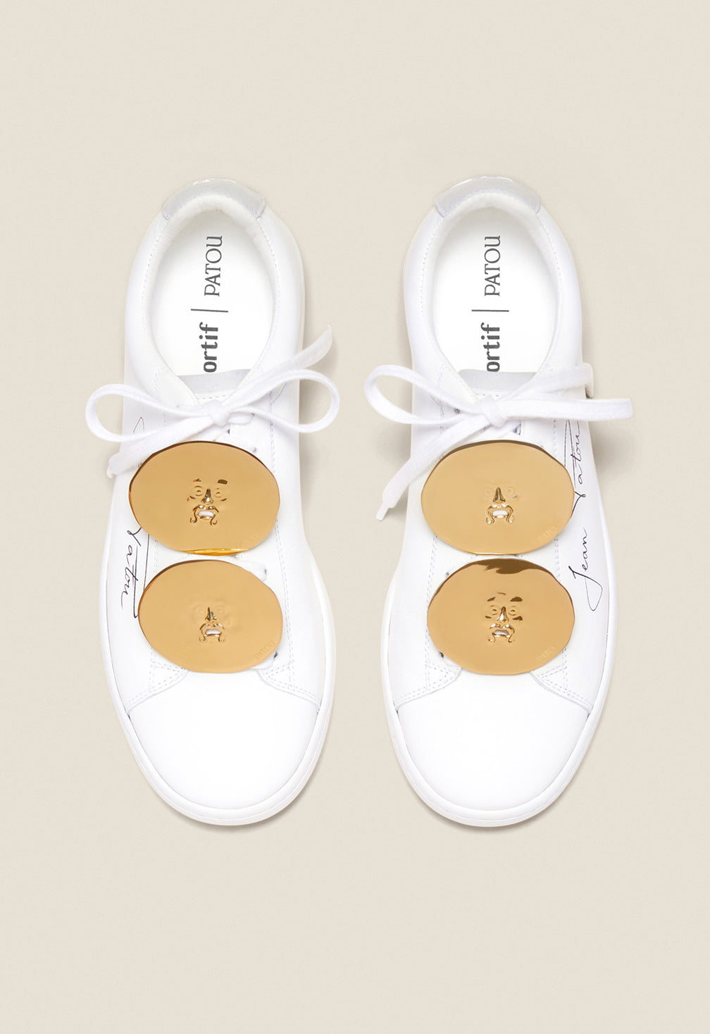 Patou - Jewellery low top sneakers - White Jewellery - A golden touch that’s totally Patou!As part of an ongoing collaboration with Le Coq Sportif. White low top sneakers with black Jean Patou signature on the side and embroidered Le Coq Sportif logo at the back. Rounded toecap. Lace-up style with “Bocca della Verità” embellishments in gold-coloured brass.