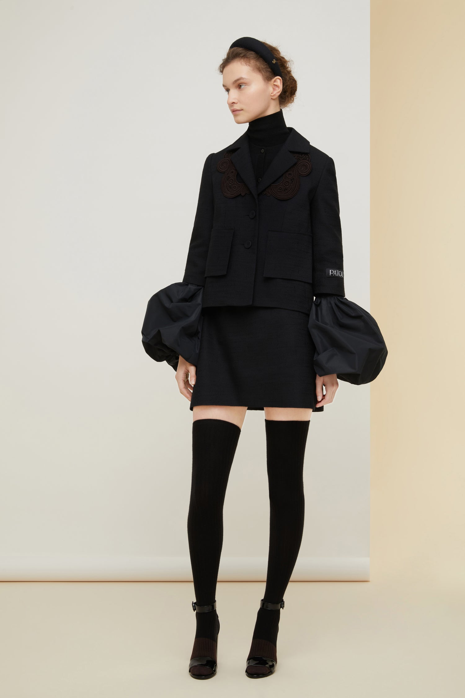 Patou - Veste courte en tweed bio avec détail en guipure - Black - La guipure qui donne de l’allure !Veste en tweed de coton et laine bio noir. Silhouette courte et ample avec fente au dos. Détails en guipure ton-sur-ton autour de l’encolure. Fermeture par deux boutons recouverts de tissus sur le devant. Étiquette blanche brodée Patou sur la manche gauche. Fausses poches à rabat. Entièrement doublée.