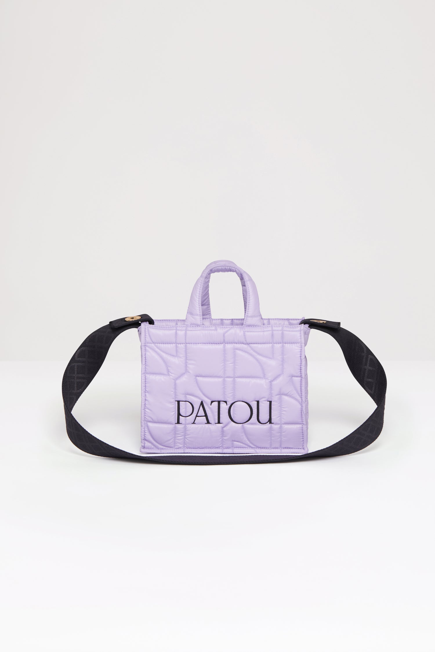 Patou - 스몰 파투 퀼티드 토트백 - Lavender - 어디든 휴대하기 쉬운 파투의 토트백. 라벤더 컬러 폴리아미드 소재 토트백. JP 올오버 퀼팅. 블랙 컬러의 Patou 레터링 로고. Patou가 새겨진 골드 버튼으로 양쪽 측면에 부착된 블랙 컬러의 엠보싱 숄더 스트랩. 두 개의 탑 핸들. 토트백 또는 숄더백으로 착용 가능.