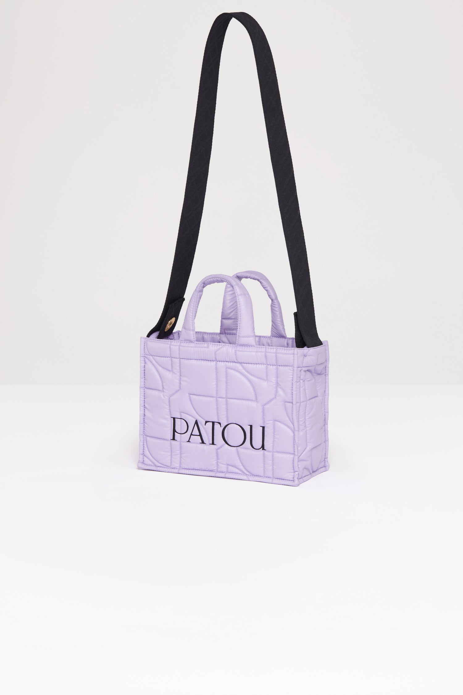 Patou - 스몰 파투 퀼티드 토트백 - Lavender - 어디든 휴대하기 쉬운 파투의 토트백. 라벤더 컬러 폴리아미드 소재 토트백. JP 올오버 퀼팅. 블랙 컬러의 Patou 레터링 로고. Patou가 새겨진 골드 버튼으로 양쪽 측면에 부착된 블랙 컬러의 엠보싱 숄더 스트랩. 두 개의 탑 핸들. 토트백 또는 숄더백으로 착용 가능.