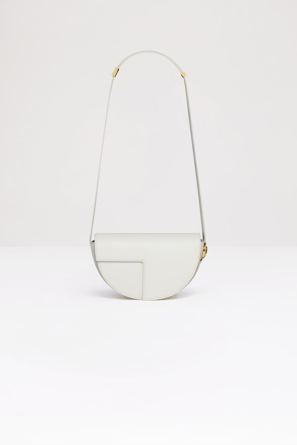 Patou - 르 파투 백 - Ivory - 업사이클링 가죽 소재로 제작된 르 파투 백.아이보리 컬러 가죽 소재. 사용되지 않은 가죽 하이드로 만든 특수 소재만을 사용하여 제작된 백. 80점 한정 생산 리미티드 에디션. JP 모노그램에서 영감을 받은 기하학적 컷아웃이 돋보이는 반원형 실루엣. 측면의 JP 모노그램 디테일 골드 톤 하드웨어. 길이 조절 가능한 스트랩으로 숄더백, 크로스백, 또는 토트백 스타일로 연출 가능. 골드 톤 JP 디테일의 자석 잠금장치. 여러 내부 수납공간.사이즈: 25cm(길이), 15cm(높이), 6cm(깊이)3가지 길이로 사이즈 조절 가능한 스트랩: 47cm(숄더백), 36cm(크로스바디백), 28cm(토트백)