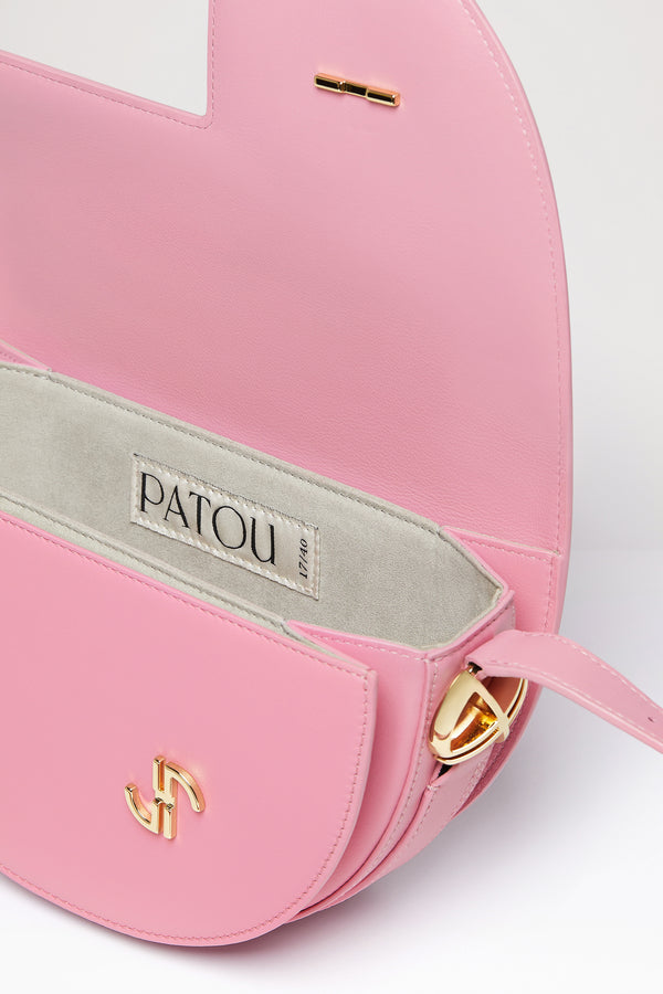 Patou - 르 파투 백 - Orchid - 업사이클링 가죽 소재로 제작된 르 파투 백.오키드 핑크 컬러의 가죽 소재. 사용되지 않은 가죽 하이드로 만든 특수 소재만을 사용하여 제작된 백. 60점 한정 생산 리미티드 에디션. JP 모노그램에서 영감을 받은 기하학적 컷아웃이 돋보이는 반원형 실루엣. 측면의 JP 모노그램 디테일 골드 톤 하드웨어. 길이 조절 가능한 스트랩으로 숄더백, 크로스백, 또는 토트백 스타일로 연출 가능. 골드 톤 JP 디테일의 자석 잠금장치. 여러 내부 수납공간.사이즈: 25cm(길이), 15cm(높이), 6cm(깊이)3가지 길이로 사이즈 조절 가능한 스트랩: 47cm(숄더백), 36cm(크로스바디백), 28cm(토트백)