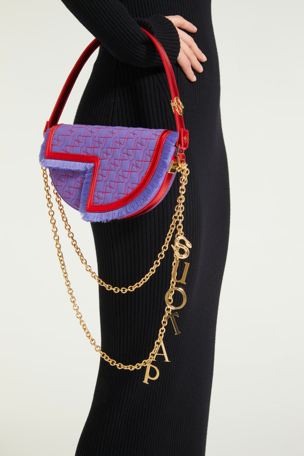 Patou - Le Petit Patou x Sita - Purple Blue Red - 콜라보레이션으로 더욱 강력해진 파투의 시그니처 백.바이올렛 컬러 데님 효과 재생 재활용 오가닉 코튼 및 레드 메탈릭 가죽 소재. DJ 겸 디자이너인 시타 아벨란(Sita Abellán)과의 특별 콜라보레이션 디자인. 고품질 데드스톡 가죽 소재. JP 모노그램에서 영감을 받은 기하학적 컷아웃이 돋보이는 반원형 실루엣. 레드 컬러의 올오버 JP 퀼팅. 측면의 Patou가 새겨진 골드 톤 하드웨어. 가장자리를 프린지로 장식한 가죽 아웃라인. 시타(Sita)의 시그니처인 뱀이 장식된 탈부착식 가죽 스트랩으로 숄더백 또는 핸드백으로 착용 가능. Patou 레터링 참과 Sita의 상징인 뱀이 장식된 골드 톤 브라스 체인 스트랩(별도 구매 가능)으로 한 번, 또는 두 번 감아 숄더백으로 착용하거나 크로스백, 또는 벨트백처럼 허리에 착용 가능.  골드 톤 JP 디테일의 자석 잠금장치. 내부 수납공간. 에코 내부 마감.사이즈: 20cm(길이), 13cm(높이), 5cm(깊이)