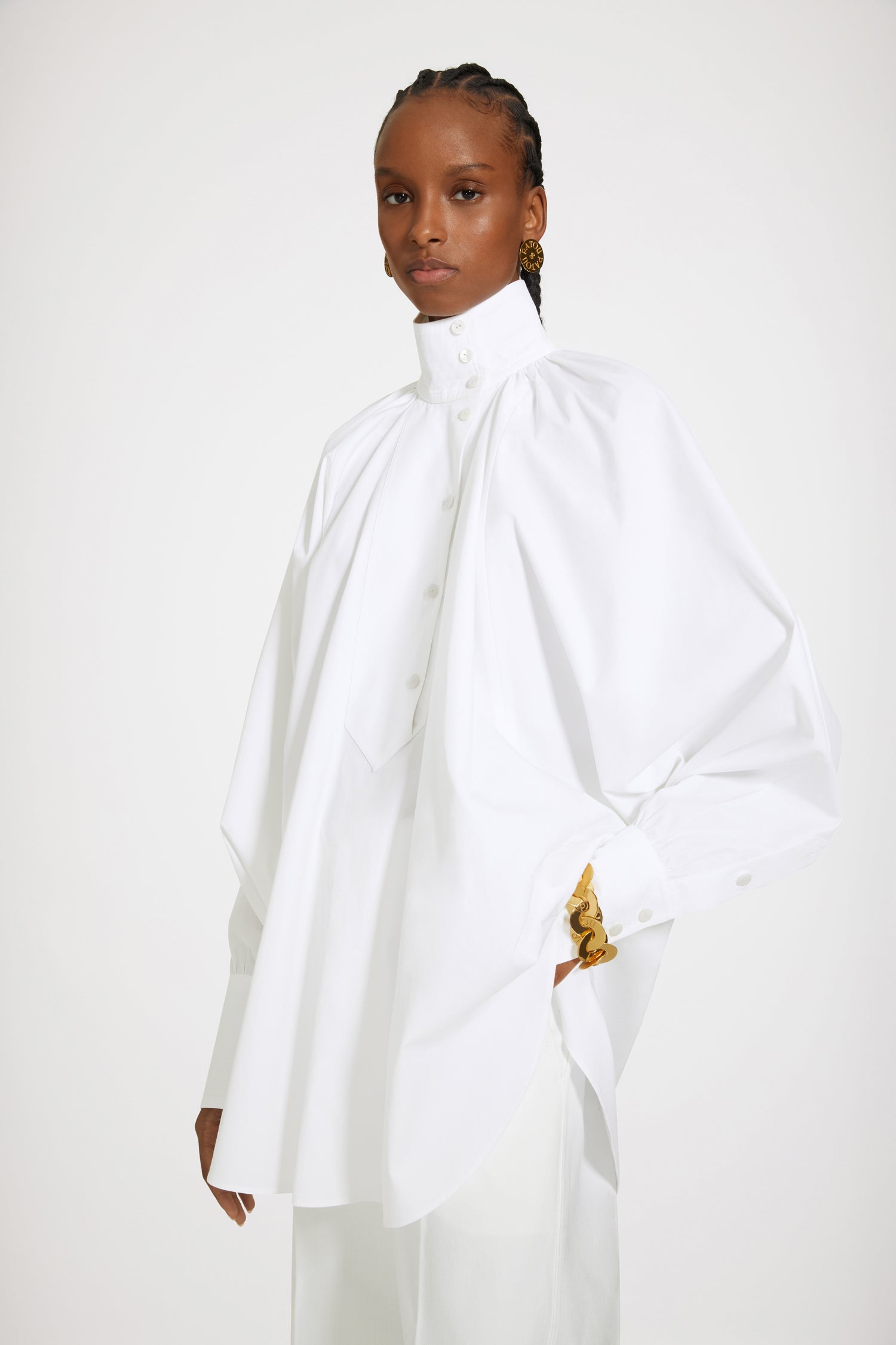 Patou - Bluse mit hohem Kragen aus Bio-Baumwolle - White - Die Malerbluse von Patou: ein modernes Meisterwerk.Bluse aus Bio-Baumwolle in Weiß. Asymmetrischer Schnitt für einen Lockeren Sitz. Pull-on-Stil mit versetzter Knopfleiste auf der Vorderseite. Hoher Kragen. Kragen hinten gerüscht. Fledermausärmel. Geknöpfte Manschetten.Lockerer Schnitt (für einen körperbetonteren Stil bitte eine Größe kleiner wählen).