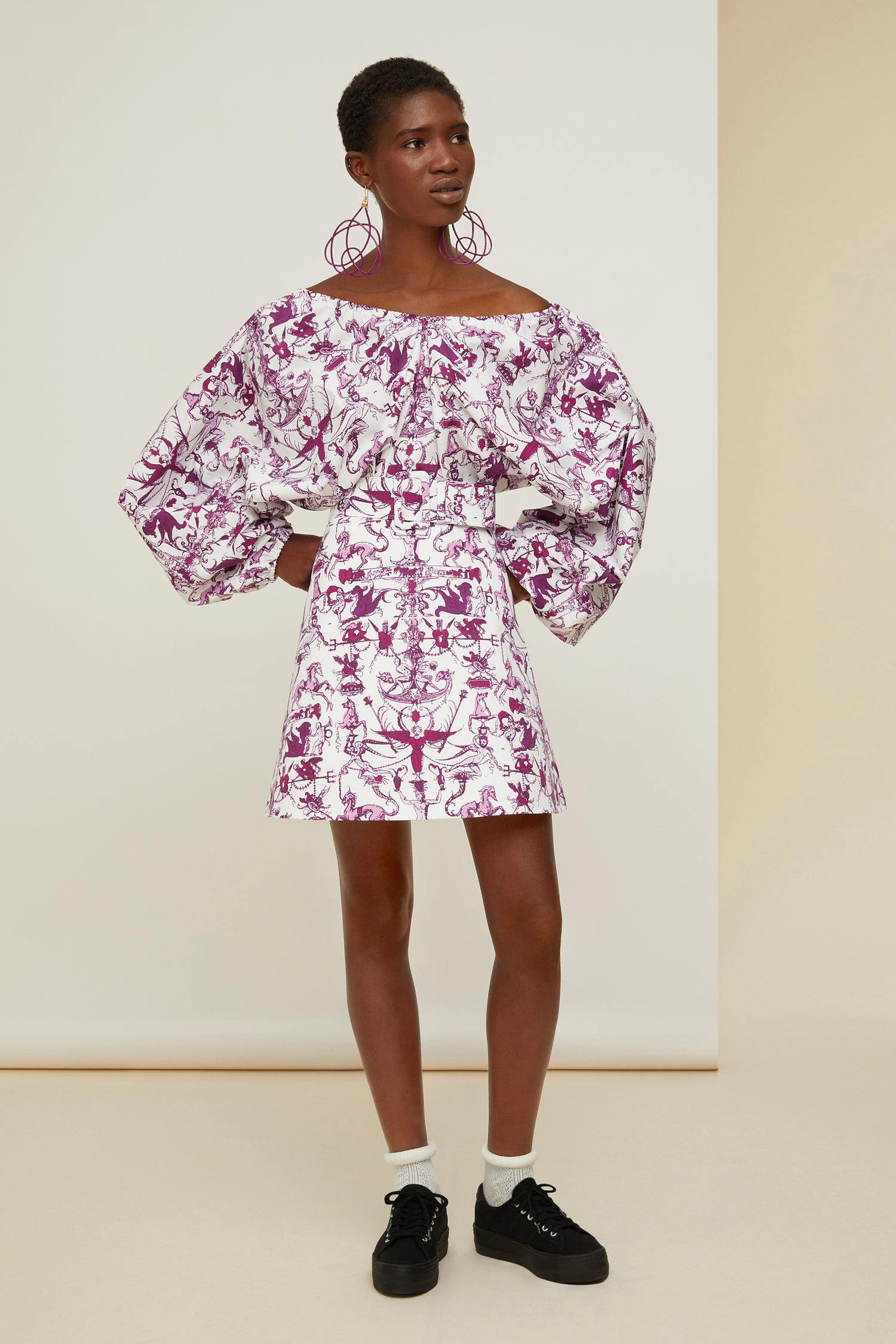 Patou - Elastisches Minikleid aus bedruckter Bio-Baumwolle - Stories And Tales - Eine Geschichte über kurze Säume und großes Volumen.  Kleid aus Bio-Baumwollpopeline mit dem „Stories and Tales“-Print der Saison. Kurz geschnitten. Elastischer V-Ausschnitt und Rücken. Voluminöse Ärmel mit elastischen Ärmelabschlüssen. Breiter größenverstellbarer Taillengürtel aus Stoff mit stoffbezogener Schließe und farblich abgestimmter Patou Logostickerei. Rockteil mit A-Linien-Schnitt.