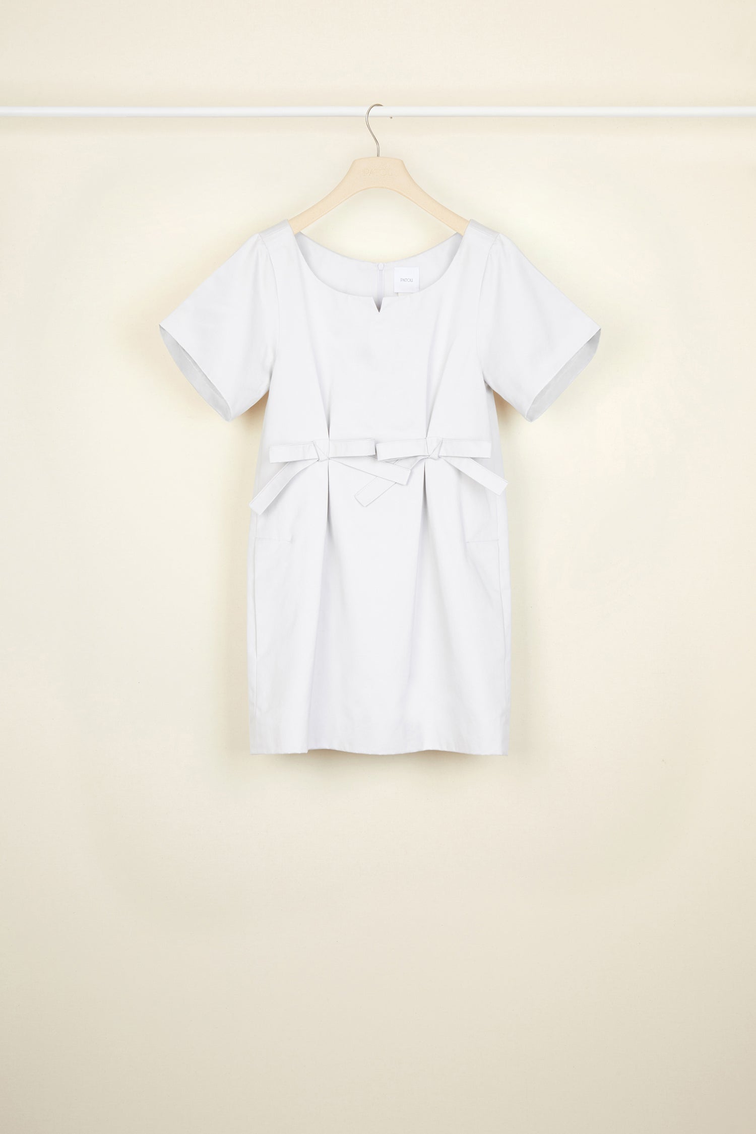 Patou - Bow cotton mini dress - Light Grey - The understated bow.Light grey eco-conscious cotton satin mini dress. Round neckline with small cut-out. Short sleeves. Two flat bows at the front. Zip fastening at the back. Pockets at the sides.