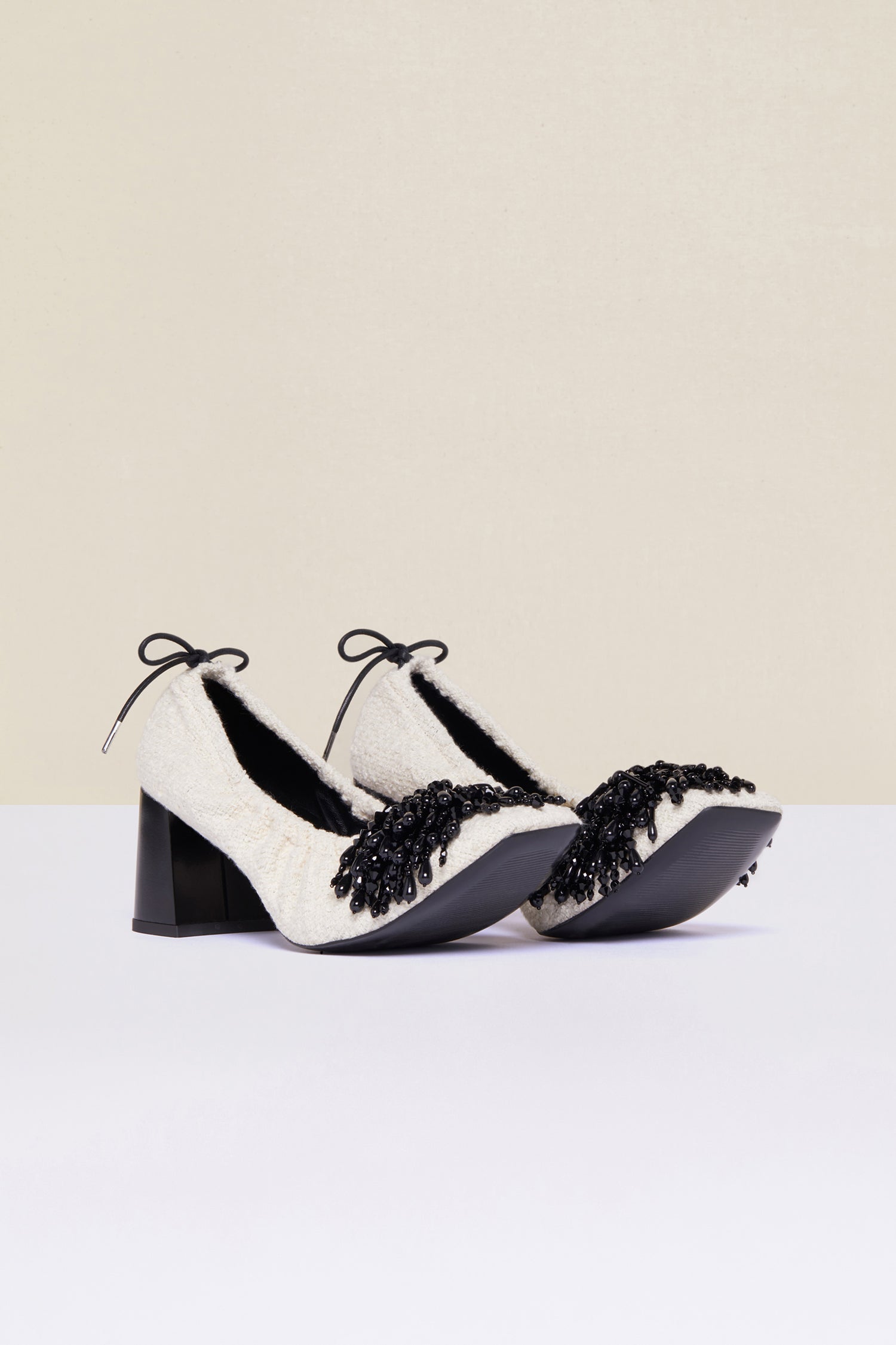 Patou - Décolleté in tweed con perle - Sand - Il tweed estivo s’indossa con le perle.Décolleté in tweed bianco sabbia con pompon in perle nere. Modello con coulisse regolabile con laccio nero da allacciare sul retro. Punta quadrata e tacco largo.