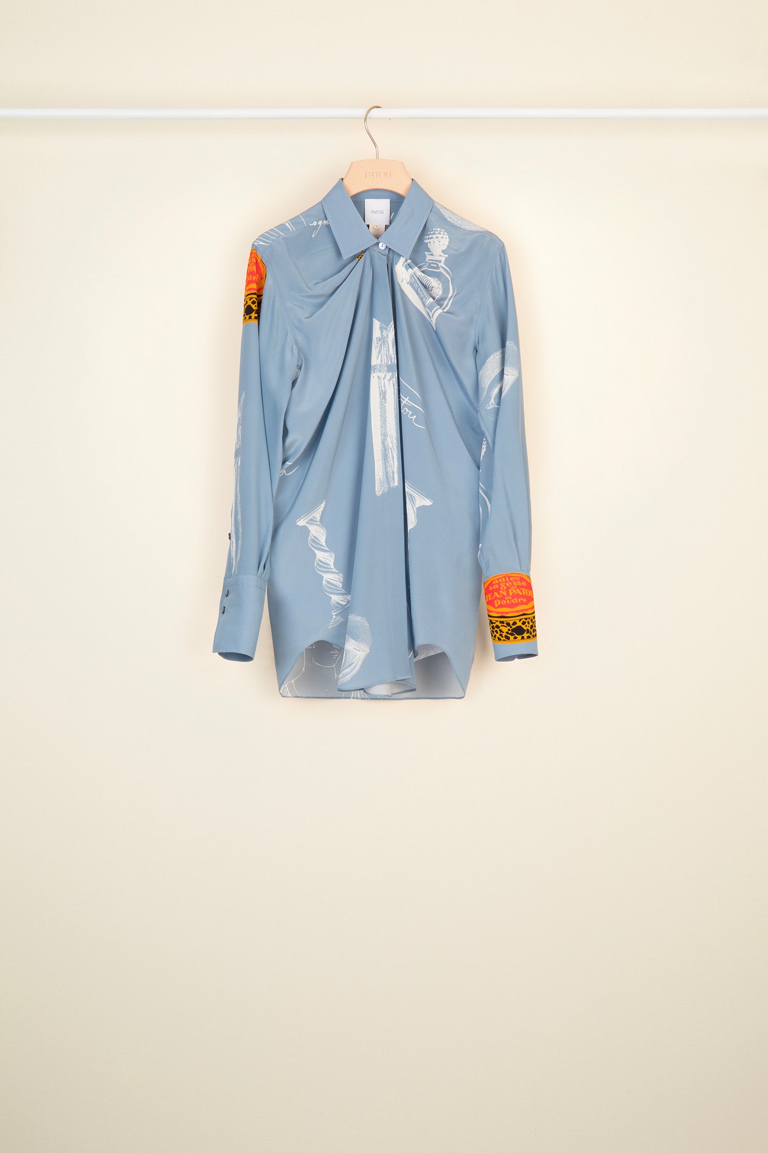 Patou - Printed draped silk blouse - Riddle Print - The fascination of Surrealism for the everyday.Printed silk blouse featuring Surrealism-inspired Patou heritage motifs. Longline draped silhouette with shirring at the neckline. Engraved mother of pearl buttons at the collar and cuffs ; concealed button fastening. Signature curved seam at the back.