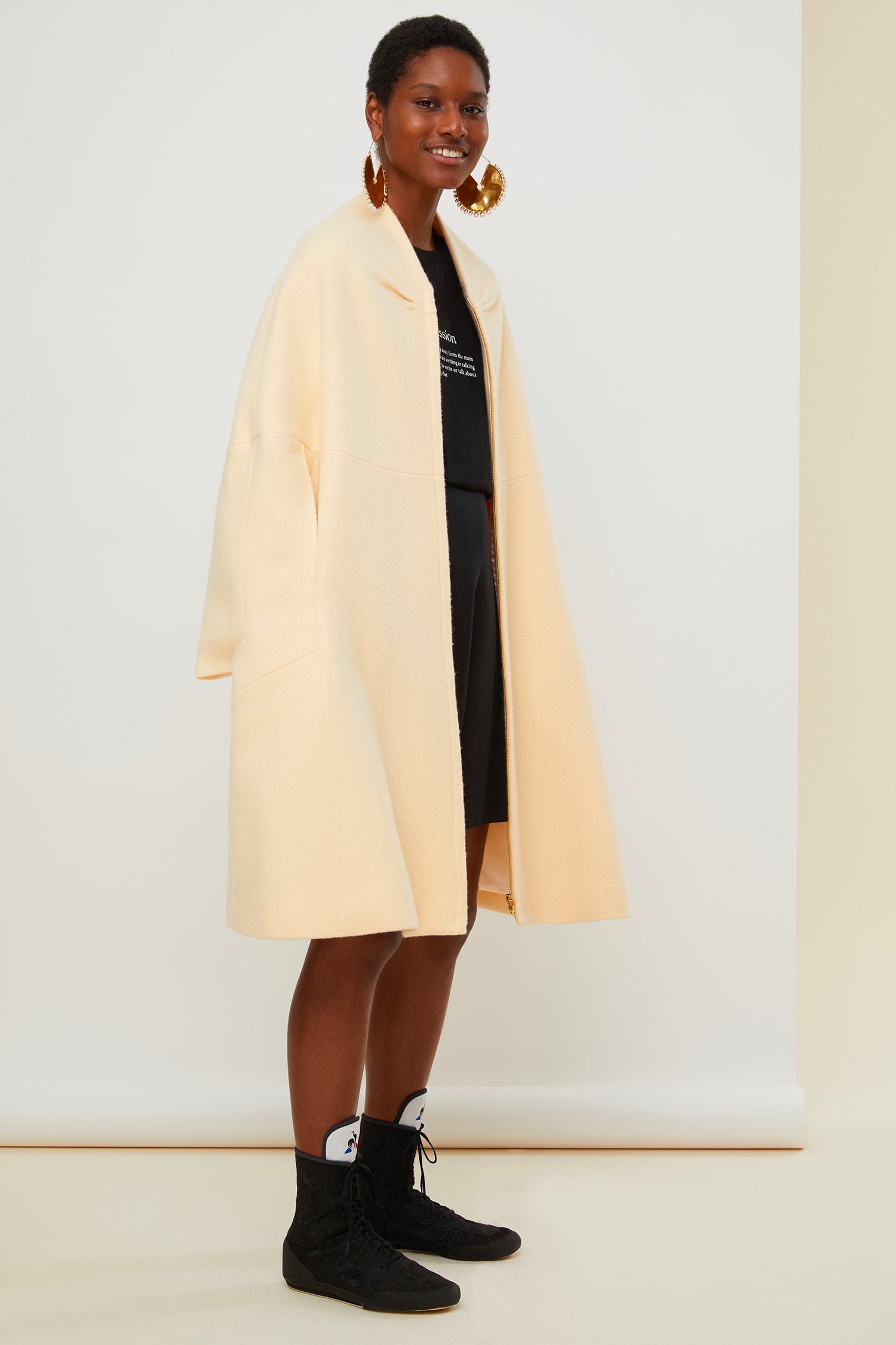 Patou - Cappotto oversize in lana - Peach Blossom - Il cappotto in versione couture. Cappotto in lana bio color fior di pesca. Silhouette svasata e morbida. Dettagli di ruche sul collo. Chiusura con cerniera oro incisa Patou. Maxi tasche ai lati. Pince geometriche sul retro. Interamente foderato.