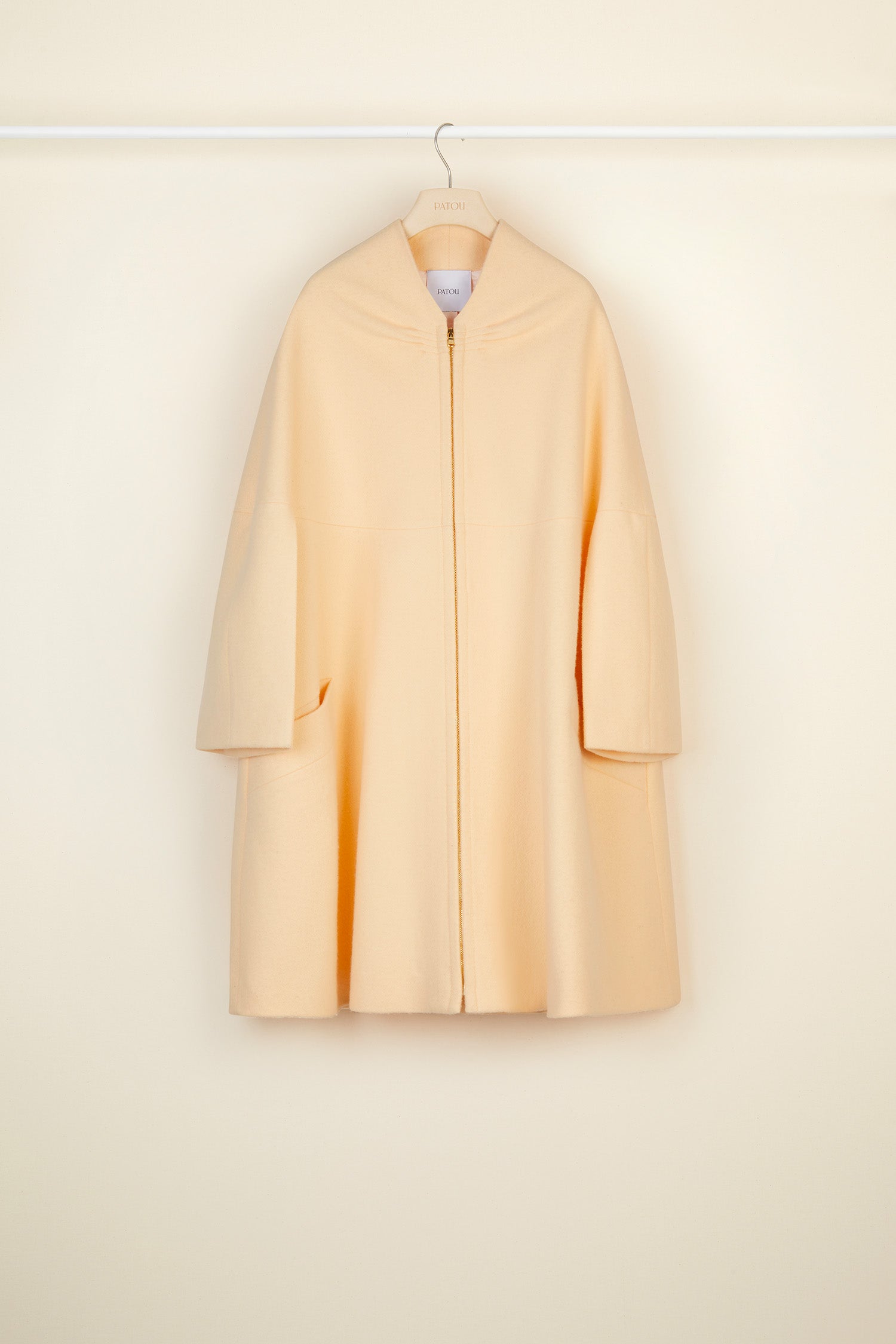 Patou - Cappotto oversize in lana - Peach Blossom - Il cappotto in versione couture. Cappotto in lana bio color fior di pesca. Silhouette svasata e morbida. Dettagli di ruche sul collo. Chiusura con cerniera oro incisa Patou. Maxi tasche ai lati. Pince geometriche sul retro. Interamente foderato.