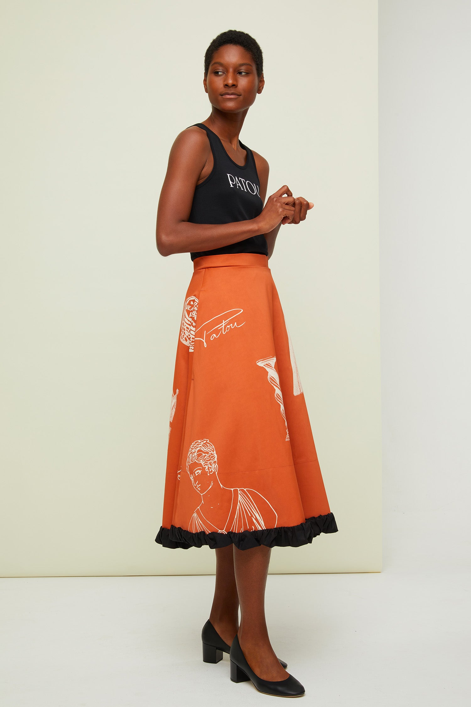 Patou - Gonna midi stampata - Sienna Riddle Print - La fodera come protagonista.  Gonna midi in tessuto tecnico misto viscosa e cotone colore terra di Siena. Disegni bianchi a contrasto in stile surrealista ispirati all&amp;#39;archivio Patou. Chiusura con cerniera sul retro. Tasche laterali. Fodera visibile in cotone nero effetto stropicciato.