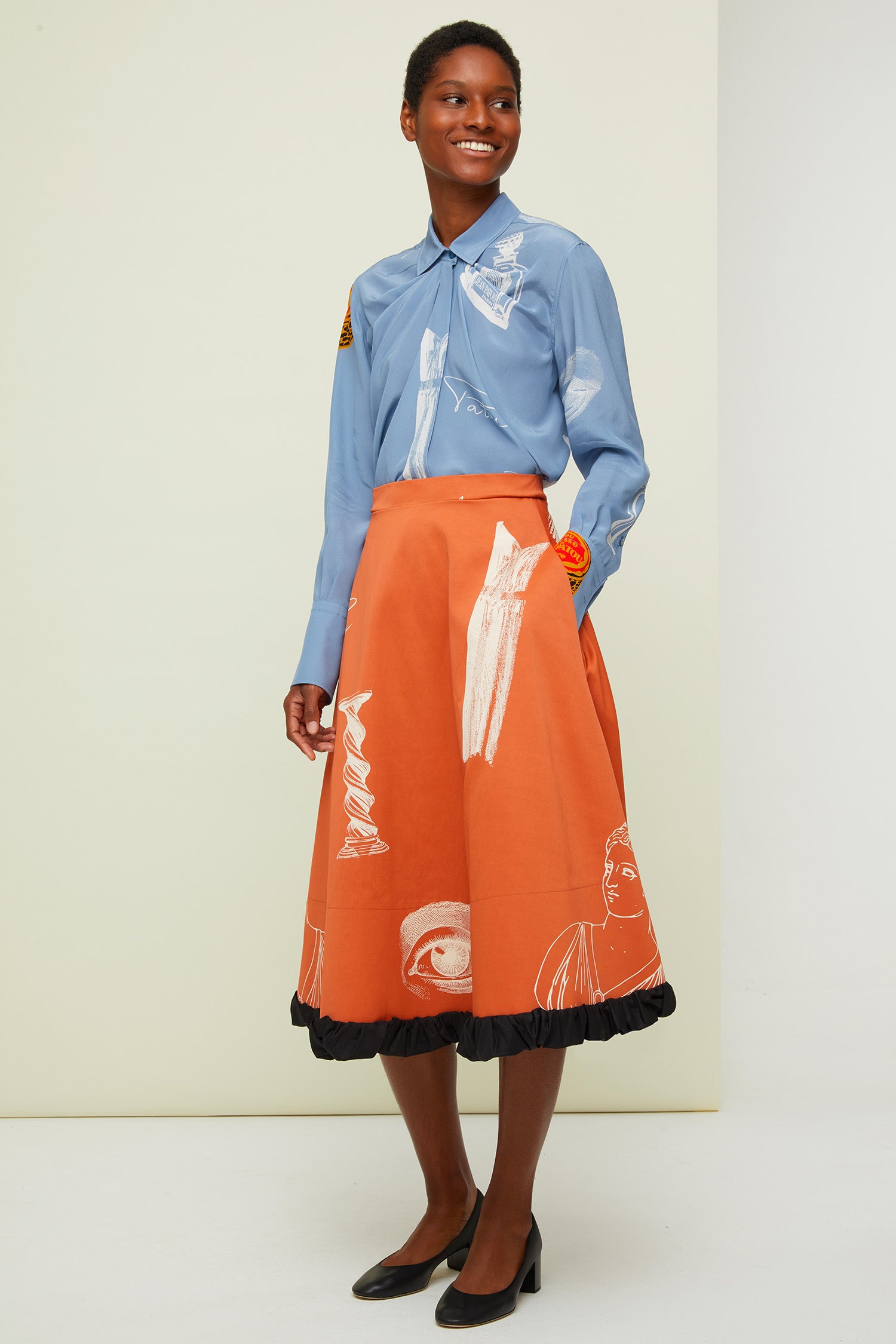 Patou - Gonna midi stampata - Sienna Riddle Print - La fodera come protagonista.  Gonna midi in tessuto tecnico misto viscosa e cotone colore terra di Siena. Disegni bianchi a contrasto in stile surrealista ispirati all&amp;#39;archivio Patou. Chiusura con cerniera sul retro. Tasche laterali. Fodera visibile in cotone nero effetto stropicciato.