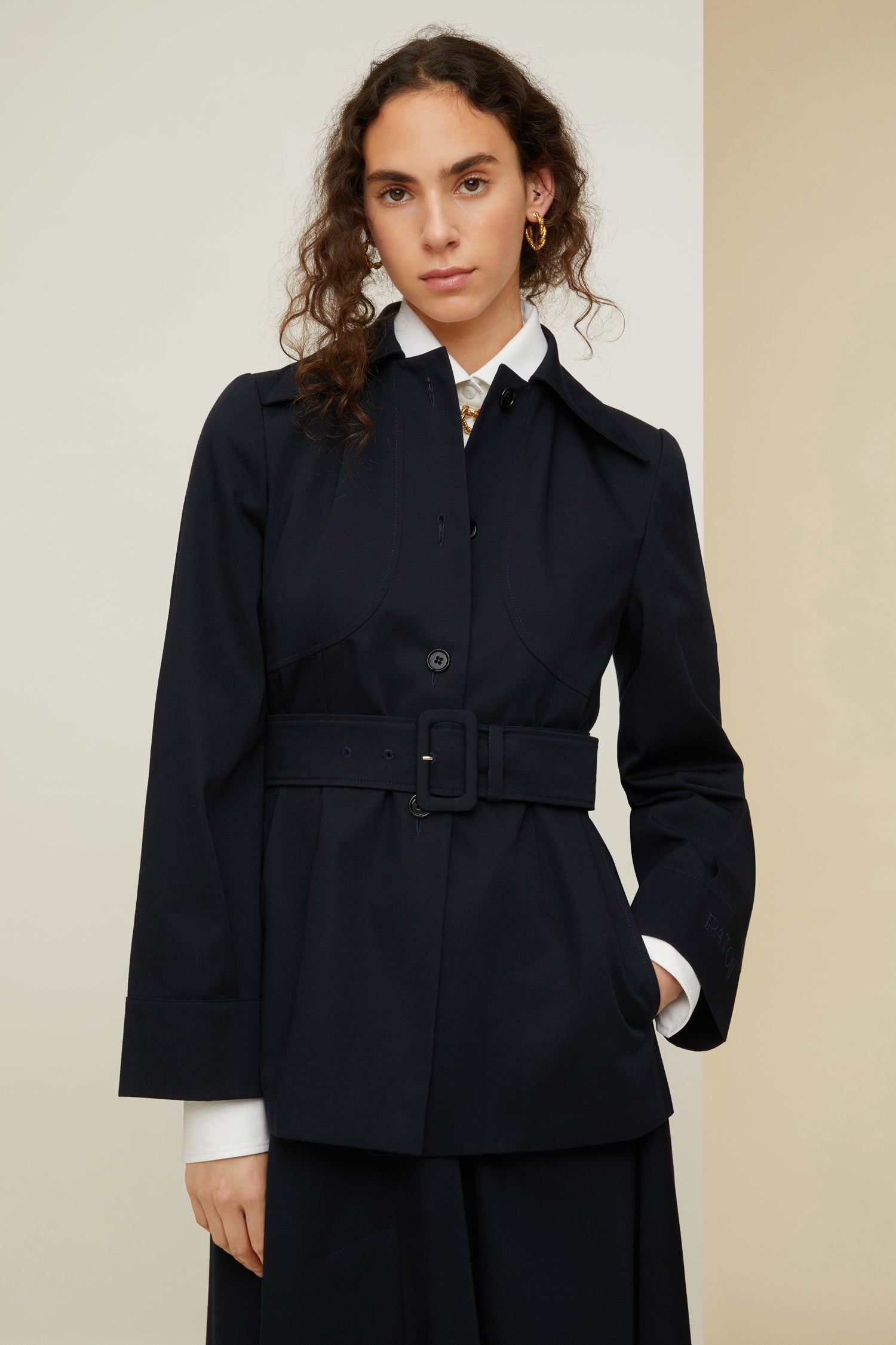 Patou - Belted jacket in organic cotton - Night Blue - Belted and flared: tailoring with the Patou touch.Night blue organic cotton jacket. Slightly flared silhouette. Spread collar. Button fastening down the front. Long sleeves with wide cuffs. Patou lettering logo embroidered on the left cuff. Wide fabric belt with adjustable buckle. Pockets at the sides. Fully lined.