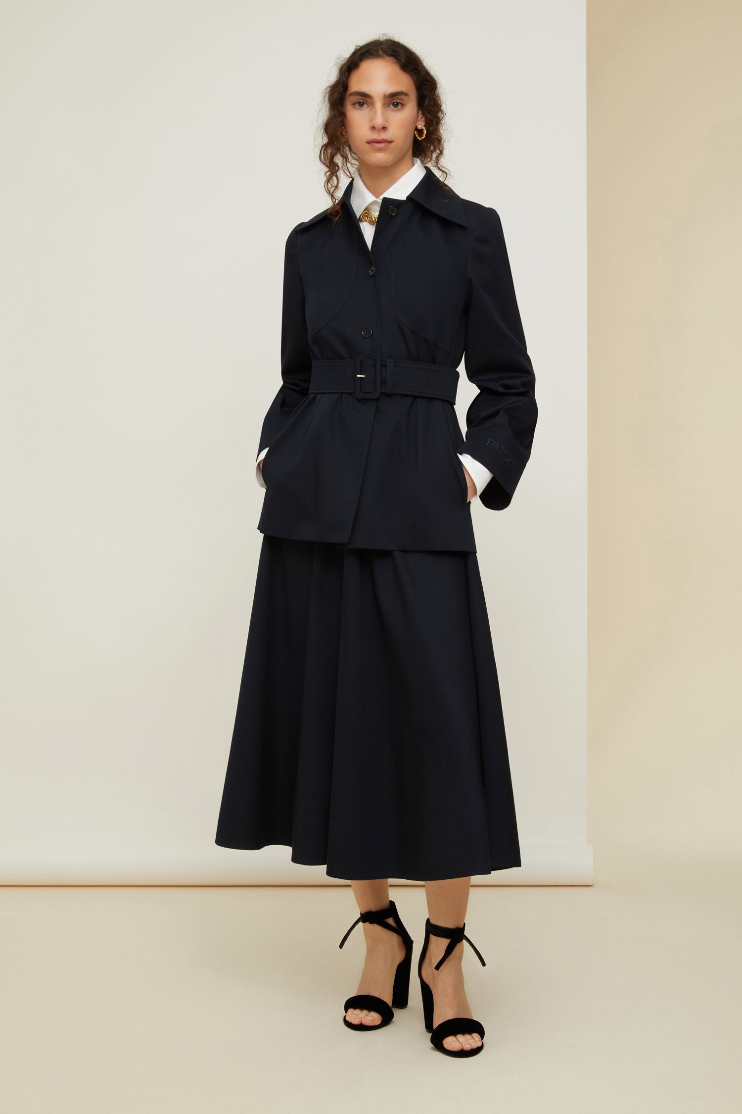 Patou - Belted jacket in organic cotton - Night Blue - Belted and flared: tailoring with the Patou touch.Night blue organic cotton jacket. Slightly flared silhouette. Spread collar. Button fastening down the front. Long sleeves with wide cuffs. Patou lettering logo embroidered on the left cuff. Wide fabric belt with adjustable buckle. Pockets at the sides. Fully lined.
