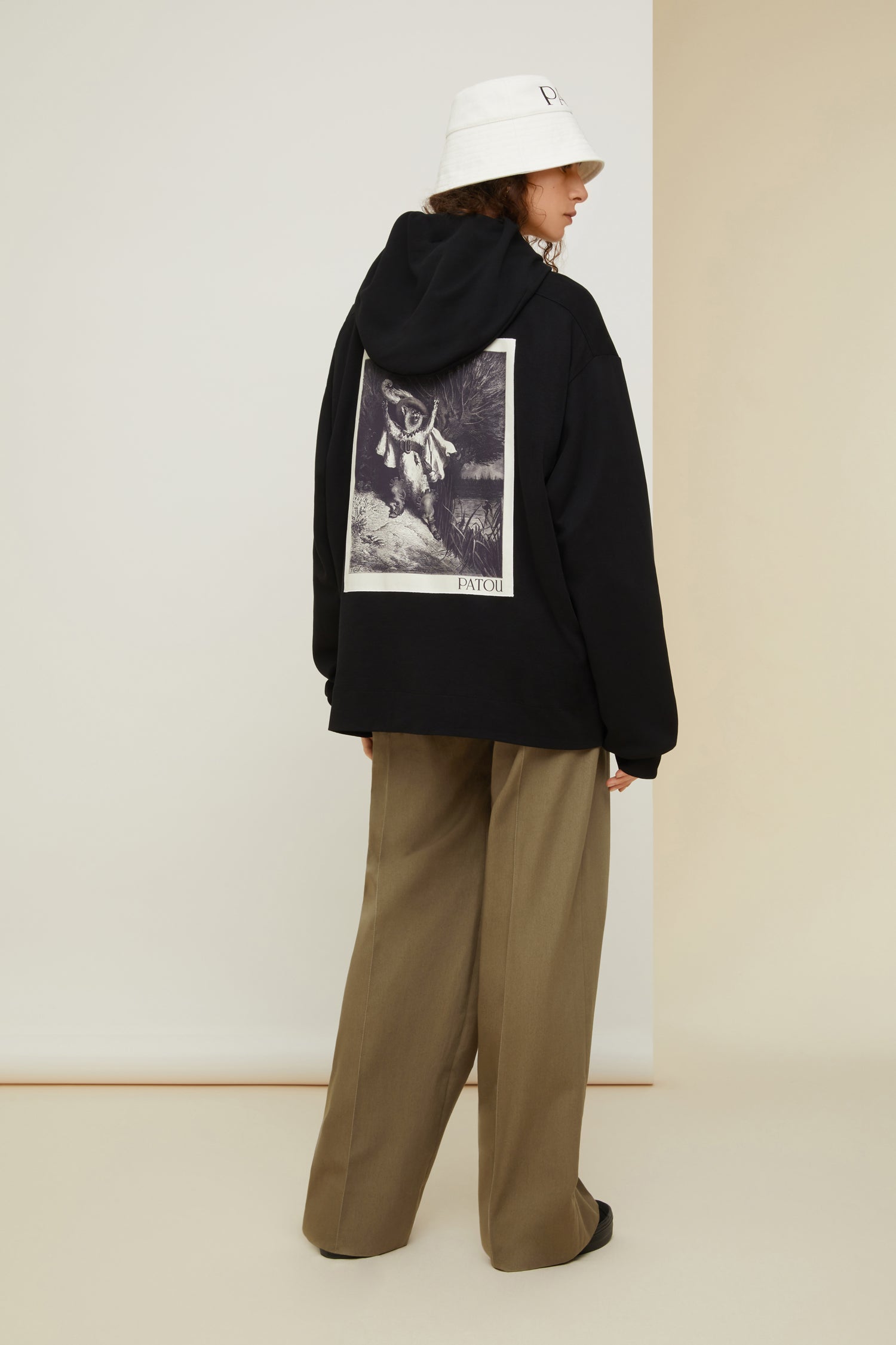 Patou - Sweatshirt Patou unisexe en coton bio - Black - Génération Patou.Sweatshirt en coton bio noir. Modèle unisexe. Col à capuche avec détail de grosgrain. Épaules tombantes. Logo Patou brodé à l’avant. Logo Patou imprimé au dos. Poignets côtelés.