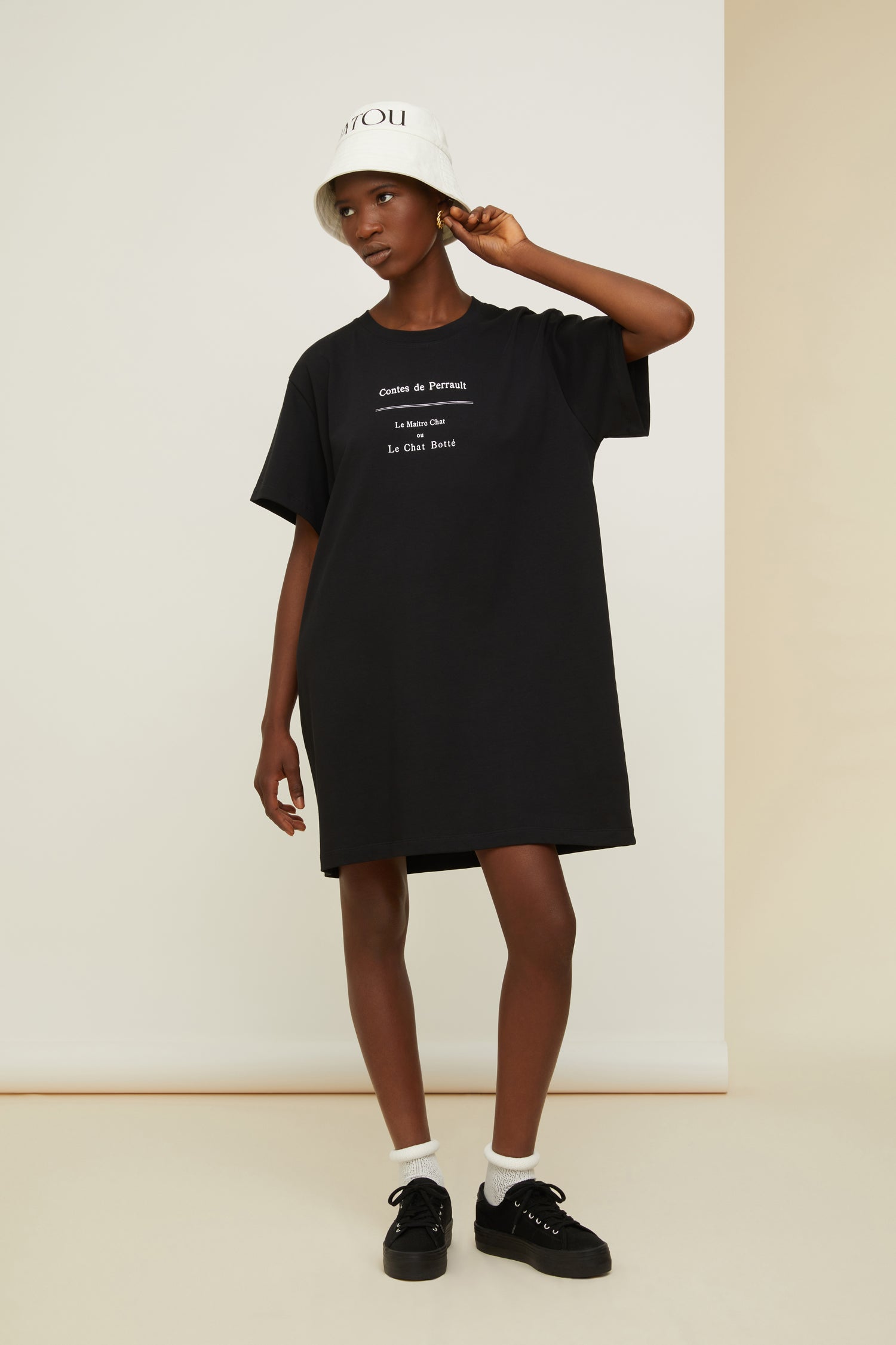 Patou - T-Shirt-Kleid „Gestiefelter Kater“ aus Bio-Baumwolle - Black - Wenn lässig und verspielt aufeinander treffen.   T-Shirt-Kleid aus Bio-Baumwolle in Schwarz. Rundhalsausschnitt. Weiße Buchstaben auf der Vorderseite. Klassische „Gestiefelter Kater“-Illustration von Gustave Doré und aufgedrucktes Patou-Buchstabenlogo auf der Rückseite.