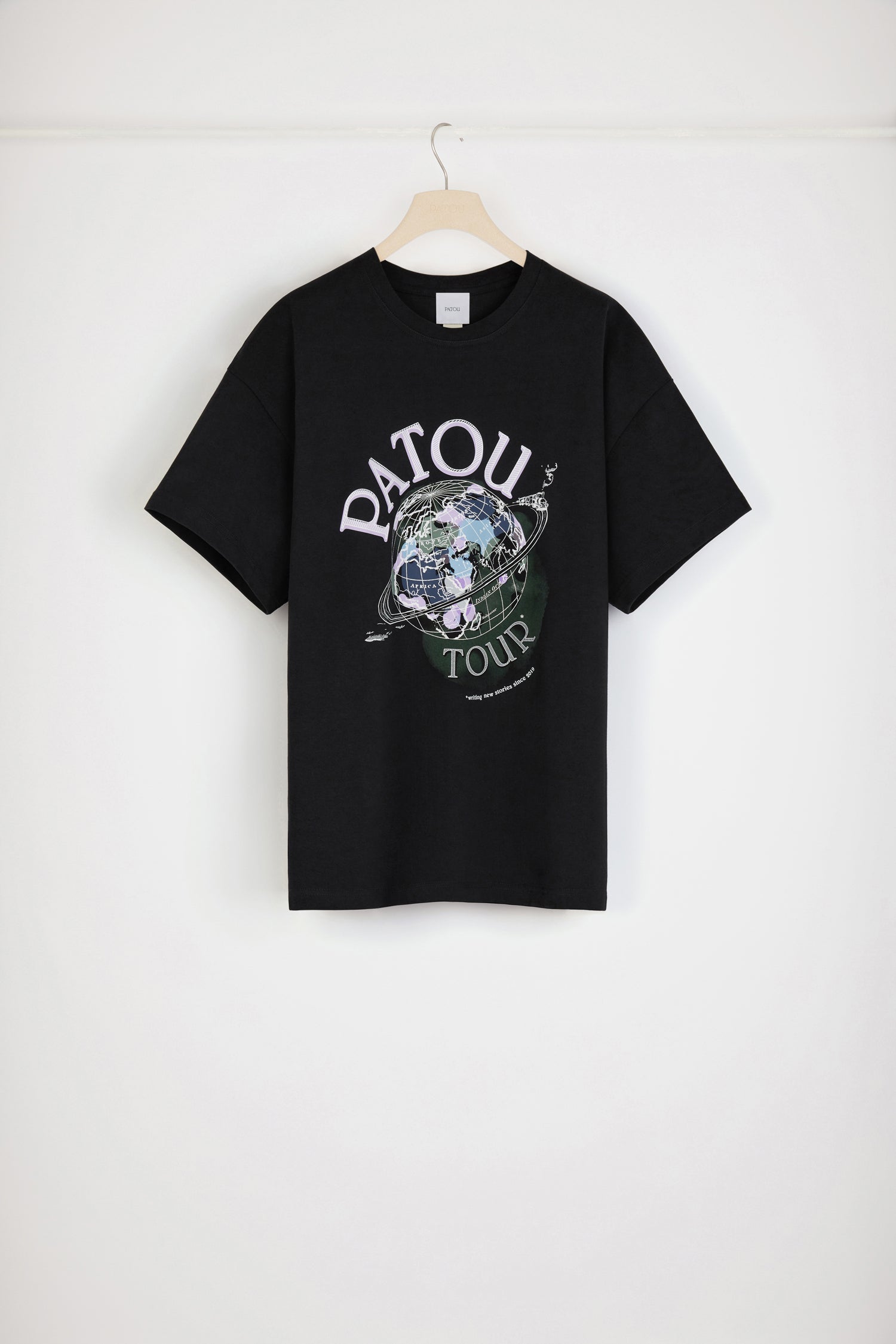 Patou - Maglietta Patou Tour in cotone bio - Black - Nuove avventure in tutto il mondo dal 2019. Maglietta in cotone bio nero. Vestibilità oversize. Stampa Patou Tour con logo e mappamondo. Monogramma JP sul retro. Look unisex (per gli uomini: prendere una taglia in più).