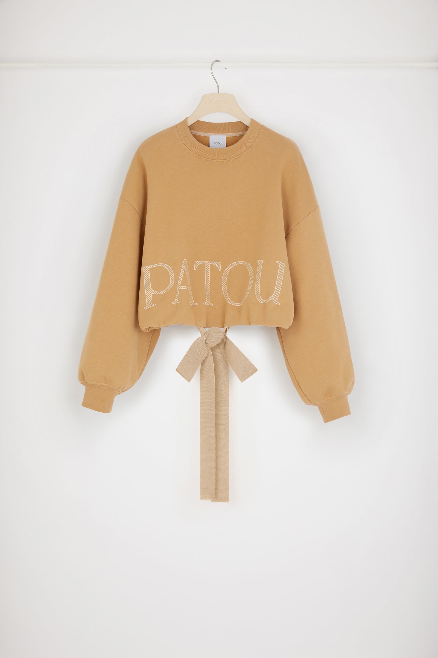 Patou - Cropped drawstring sweatshirt in organic cotton - Biscuit - Grosgrain makes a big statement. Biscuit beige organic cotton sweatshirt. Cropped silhouette. Crewneck. Ribbed collar and cuffs. Dropped shoulders. Patou logo in hatched lettering. Grosgrain drawstring hem. Loose fit (select one size down for a fitted look).