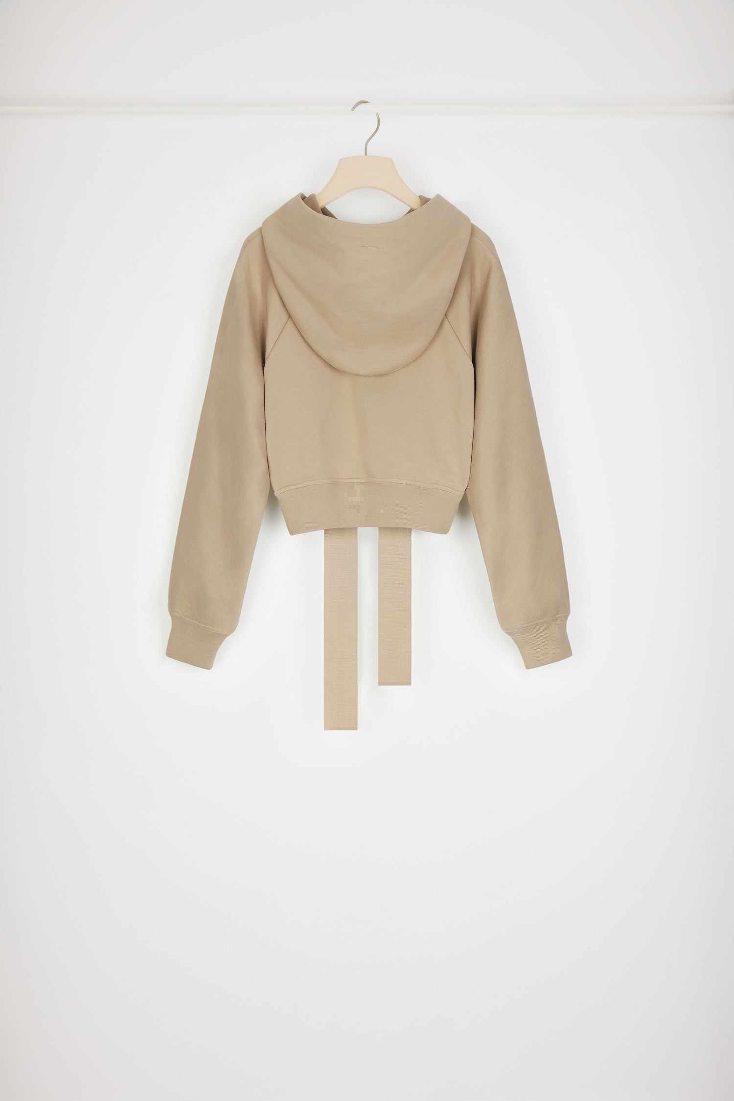 Patou - Felpa corta con logo medaglione in cotone bio - Parchment - Variazione di stagione sulla felpa Patou.Felpa in cotone bio beige pergamena. Modello corto. Collo con cappuccio e lacci in grosgrain. Logo Patou medaglione ricamato sul davanti. Maniche raglan. Polsini e vita a costine.