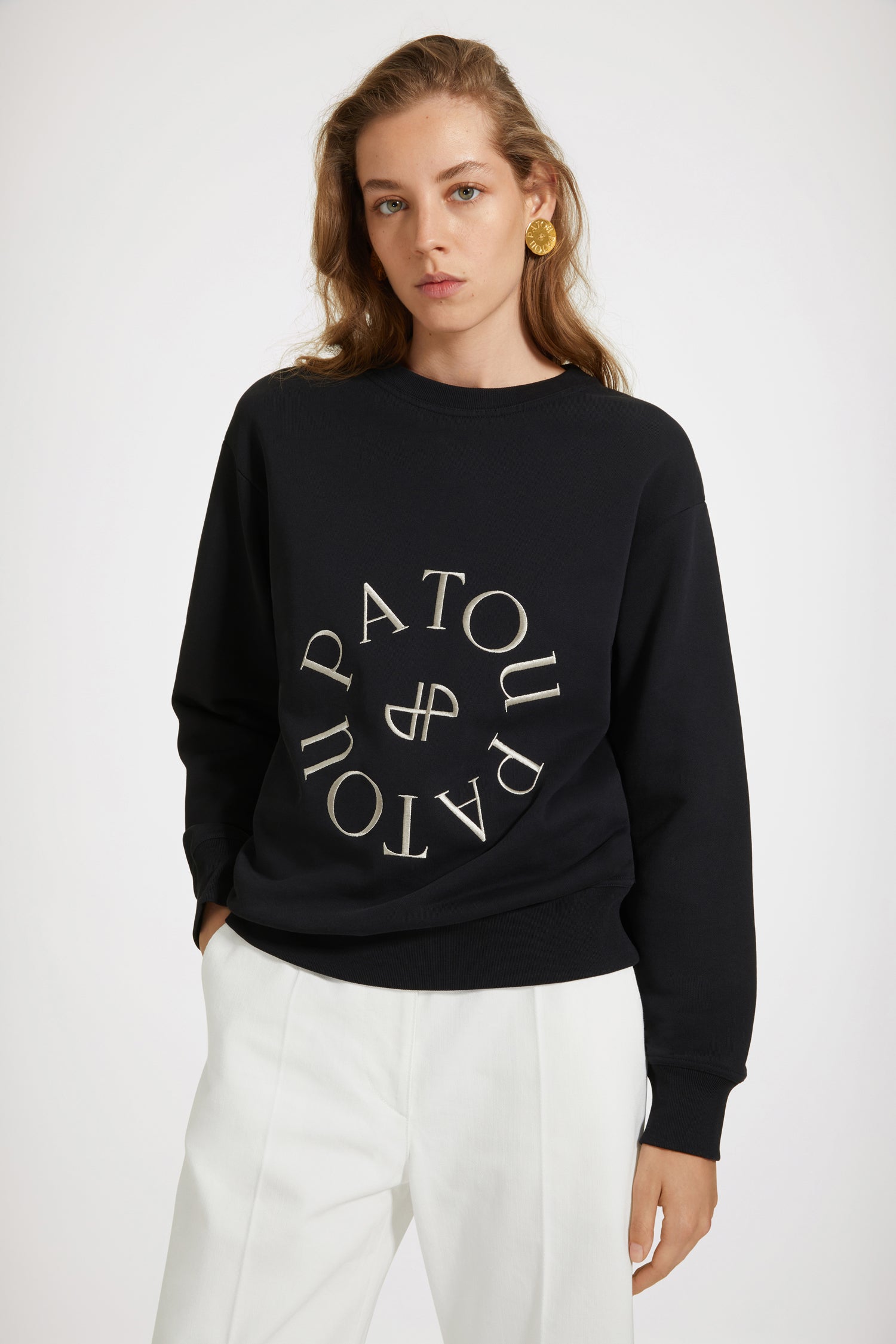 Patou - Medallion logo sweatshirt in organic cotton - Black - Le sweatshirt Patou: variation on a signature.Black organic cotton sweatshirt. Regular fit. Crewneck. Ribbed collar, cuffs and waist. Patou medallion logo embroidered at the front.