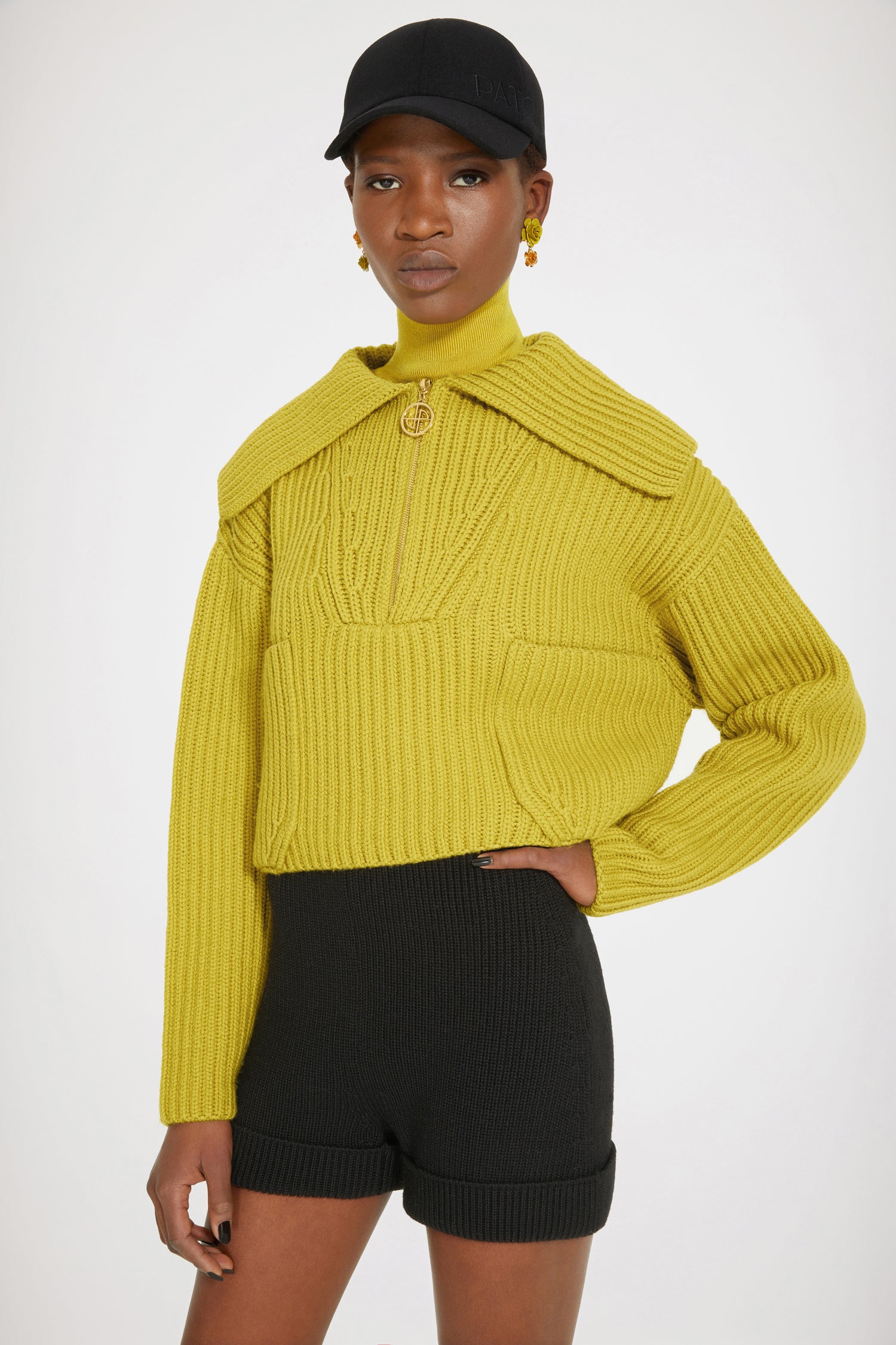 Patou - Maglione in lana a costine con zip - Absinthe - Lo zip JP brilla sulla lana.Maglione in lana merino giallo assenzio. Maglia a costine. Modello corto. Collo oversize; zip oro con dettaglio JP ispirato agli archivi Jean Patou. Dettagli di trecce intorno al collo. Due tasche sul davanti.