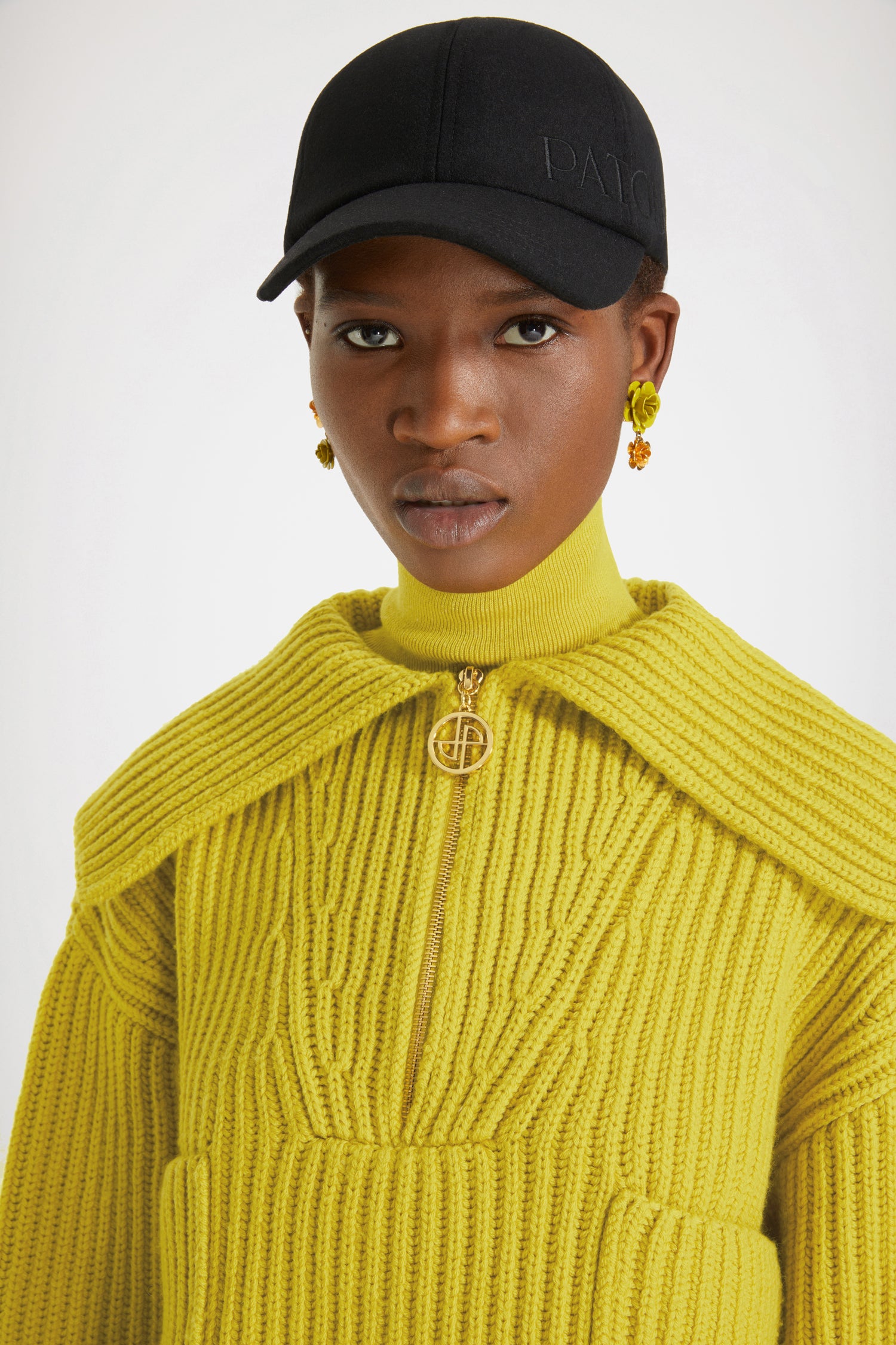 Patou - Maglione in lana a costine con zip - Absinthe - Lo zip JP brilla sulla lana.Maglione in lana merino giallo assenzio. Maglia a costine. Modello corto. Collo oversize; zip oro con dettaglio JP ispirato agli archivi Jean Patou. Dettagli di trecce intorno al collo. Due tasche sul davanti.