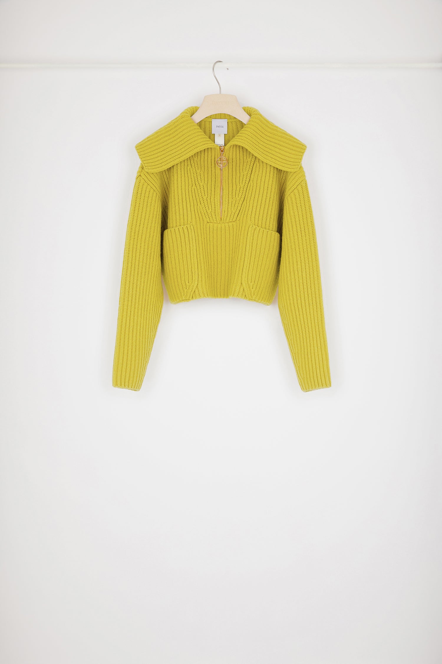 Patou - Maglione in lana a costine con zip - Absinthe - Lo zip JP brilla sulla lana.Maglione in lana merino giallo assenzio. Maglia a costine. Modello corto. Collo oversize; zip oro con dettaglio JP ispirato agli archivi Jean Patou. Dettagli di trecce intorno al collo. Due tasche sul davanti.