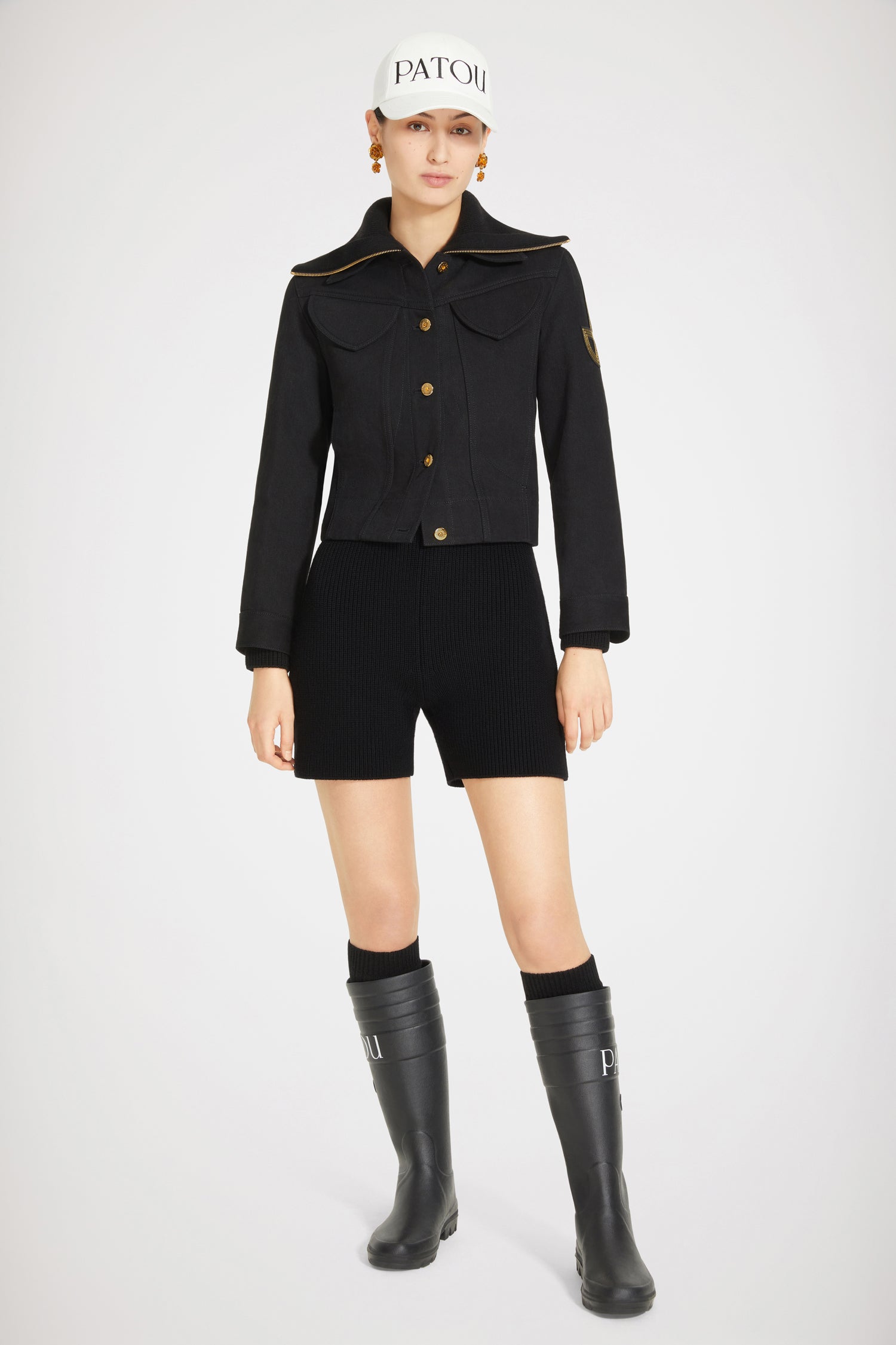 Patou - Tuta in lana a costine con zip - Black - Lana a costine e zip JP creano la tuta perfetta. Tuta in lana merino nera. Maglia a costine. Collo oversize; zip oro con dettaglio JP ispirato agli archivi Jean Patou. Modello corto.