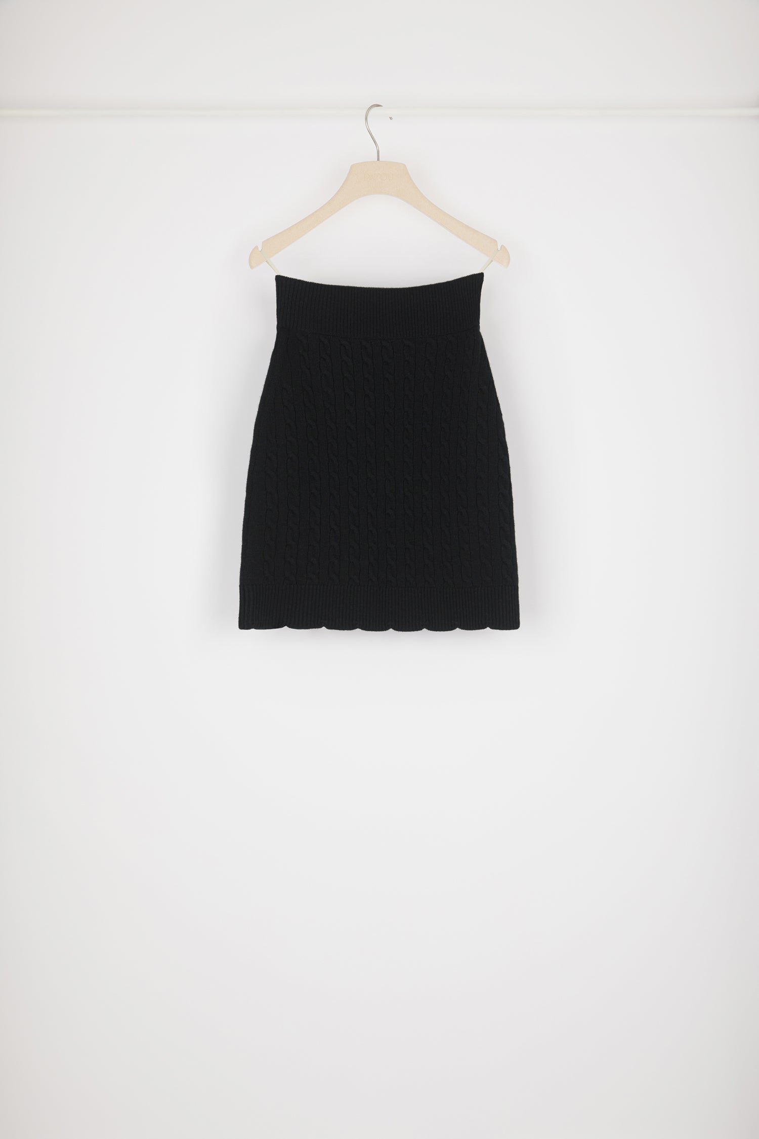Patou - Jupe torsadée en laine - Black - Les torsades habillent la jupe.Jupe en laine mérinos noire. Détails de torsades. Coupe ajustée. Taille haute. Bord festonné